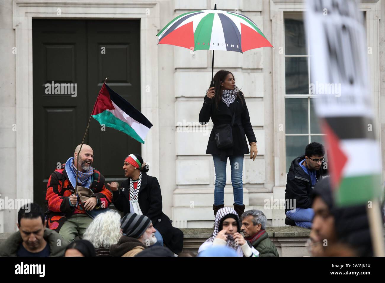 Die Demonstranten ruhen in Whitehall, während Hunderttausende pro-palästinenser marschieren und einen dauerhaften Waffenstillstand in Gaza fordern. Stockfoto