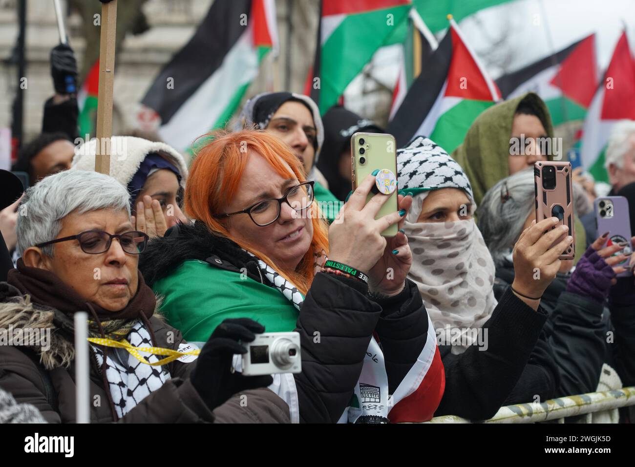 Demonstranten filmen auf ihren Telefonen als Hunderttausende pro-palästinensische Demonstranten, die eine Waffenruhe in Gaza-Stadt in Whitehall fordern. Stockfoto