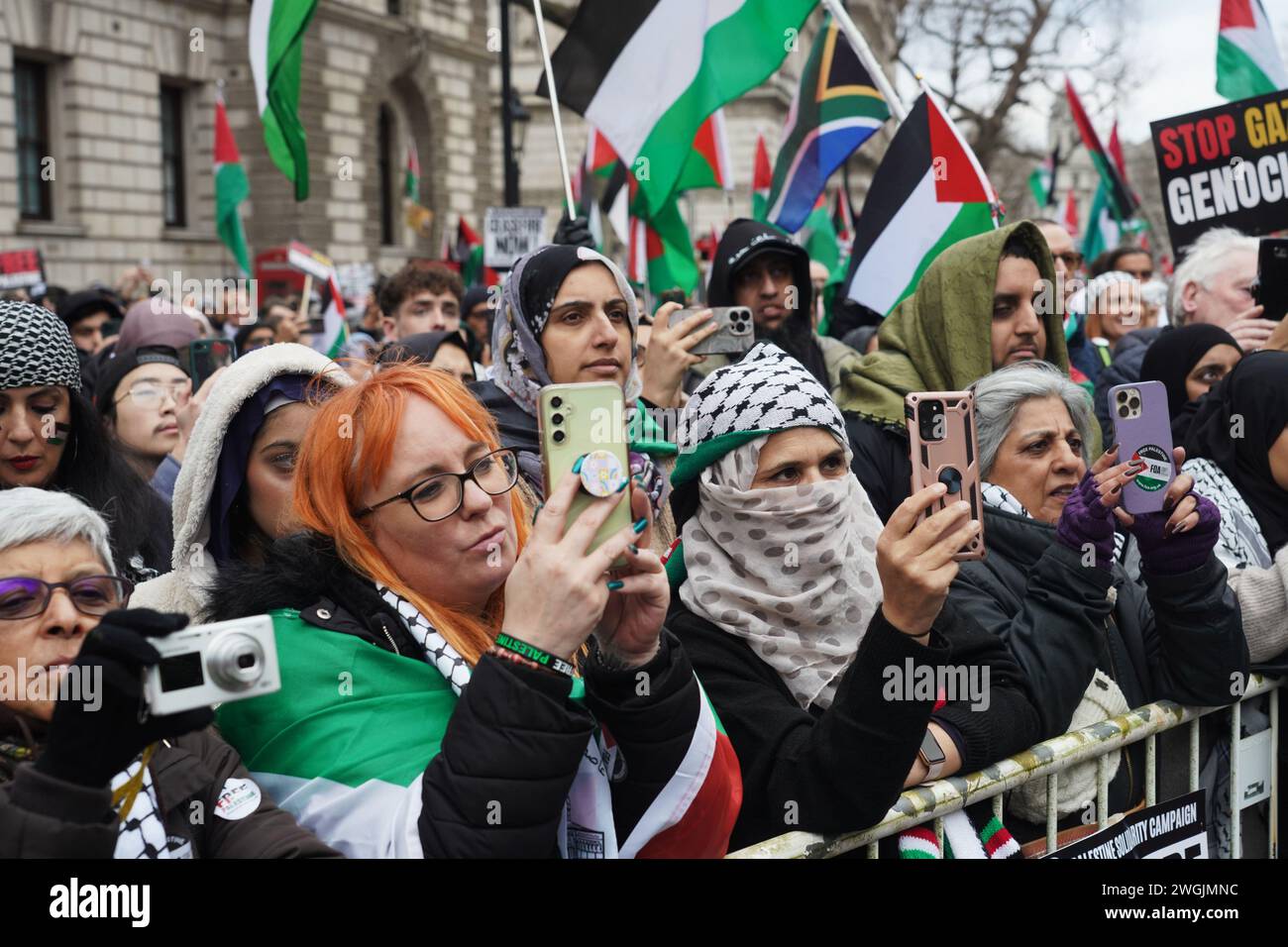 Demonstranten filmen auf ihren Telefonen als Hunderttausende pro-palästinensische Demonstranten, die eine Waffenruhe in Gaza-Stadt in Whitehall fordern. Stockfoto