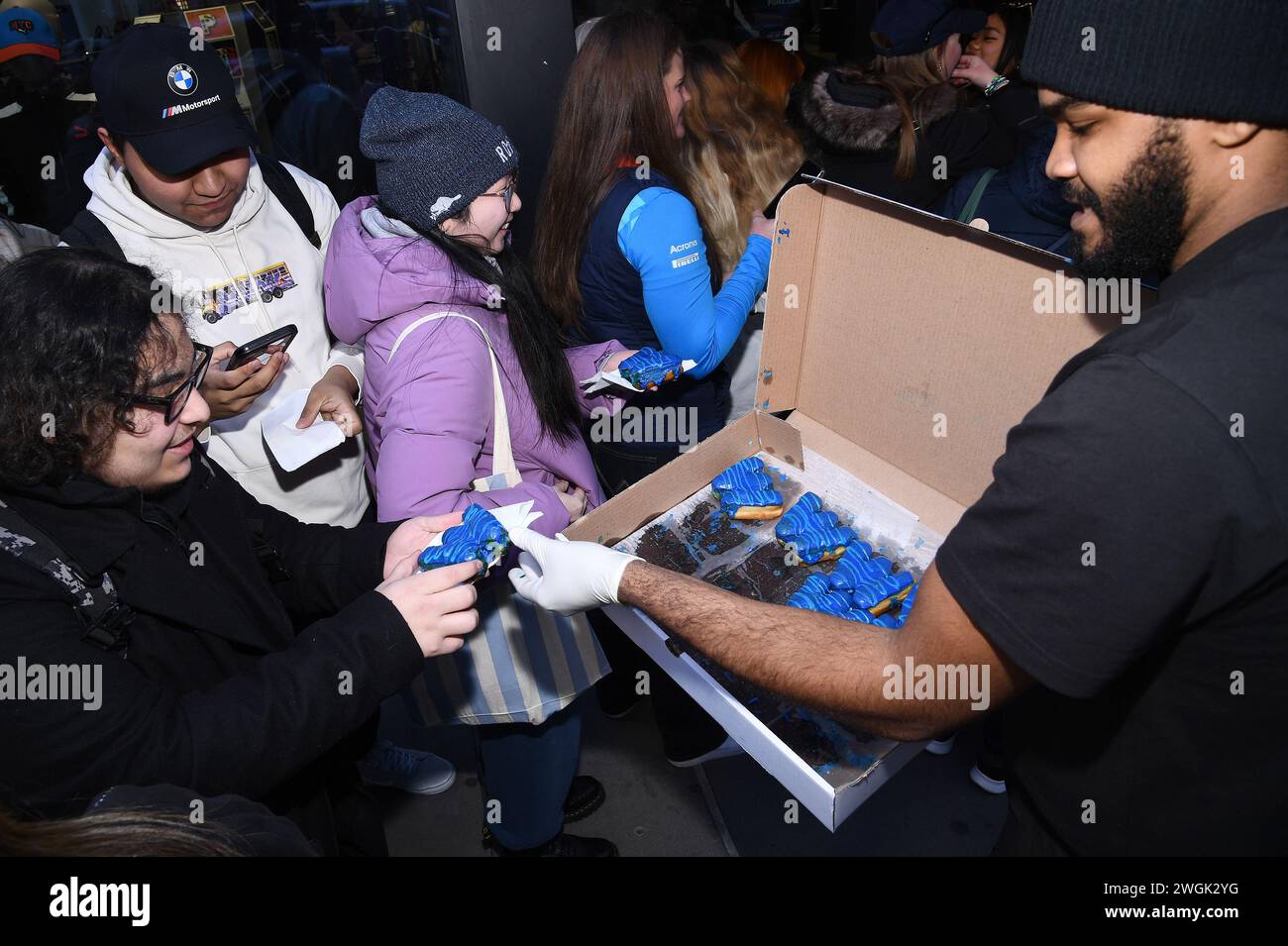 New York, USA. Februar 2024. Fans, die draußen warten, werden beim Williams Racing 2024 Season Launch mit „W“-förmigen und blauen Frosting-überzogenen Doughnuts und der Enthüllung im Puma 5th Avenue Store, New York, NY, 5. Februar 2024, angeboten. (Video von Anthony Behar/SIPA USA) Credit: SIPA USA/Alamy Live News Stockfoto