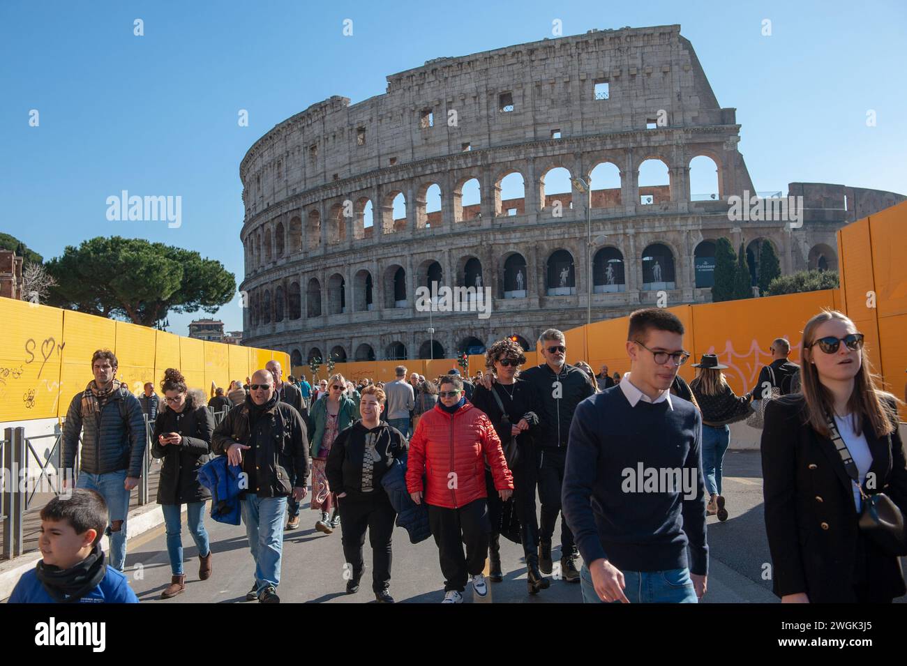4. Februar 2024 – Rom, Italien: Touristen schlendern die Via dei Fori Imperiali, die U-Bahn C auf beiden Seiten und das Kolosseum im Hintergrund. © Andrea Sabbadini Stockfoto