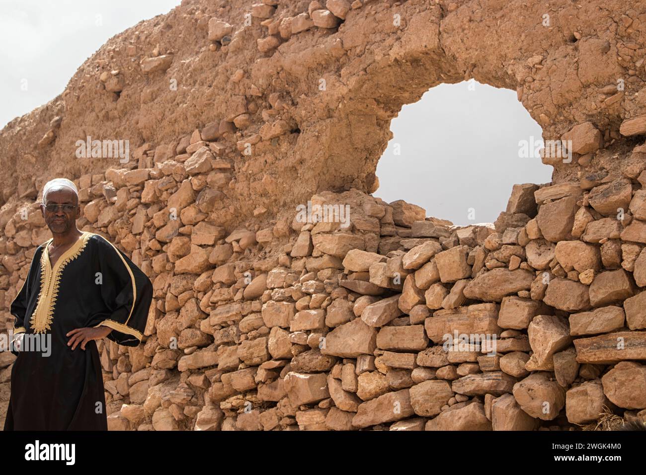 Porträt eines einheimischen arabischen Mannes aus dem Dorf Merzouga, einer kleinen marokkanischen Stadt in der Sahara, nahe der algerischen Grenze. Es ist bekannt als Tor zum Erg Chebbi, einer riesigen Sanddünen nördlich der Stadt. Westlich von Merzouga ist Dayet Srji ein saisonaler Salzsee, der im Sommer oft trocken ist. Wenn er voll ist, zieht er eine große Auswahl an Zugvögeln und Wüstenvögeln an, darunter Wüstenschaumler, ägyptische Nachtschläge und gelegentlich Flamingos. Marokko. Stockfoto