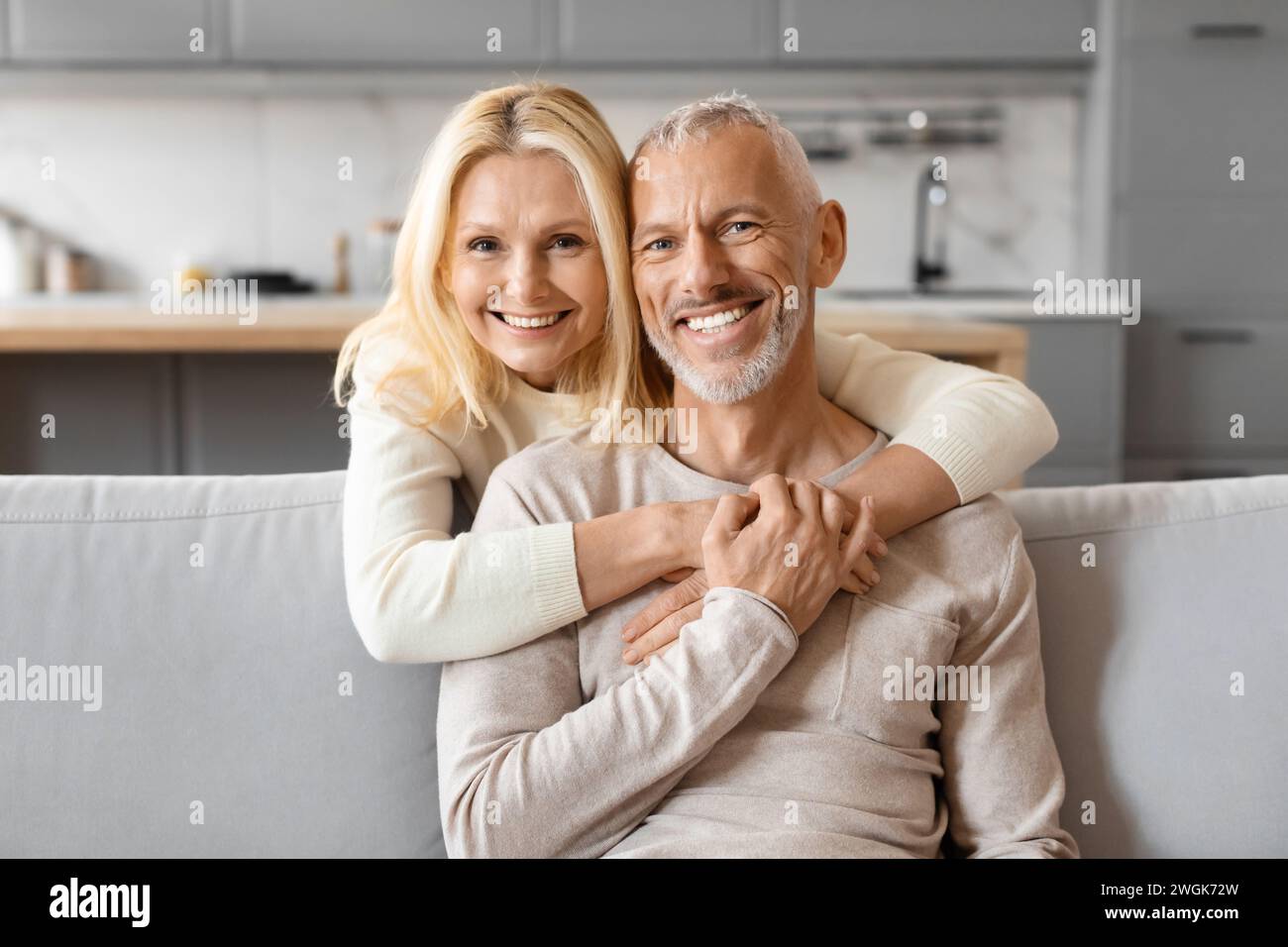Liebe schöne ältere Frau, die ihren Mann umarmt, Inneneinrichtung Stockfoto