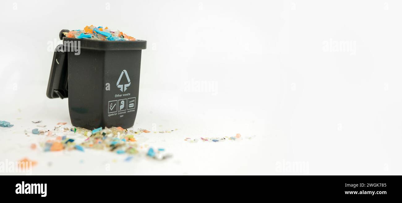 Makroaufnahme eines Mini-Plastikmüllbehälters voller Mikroplastik. Das Konzept der Wasserverschmutzung und der globalen Erwärmung. Makroaufnahme mit geringer Schärfentiefe Stockfoto