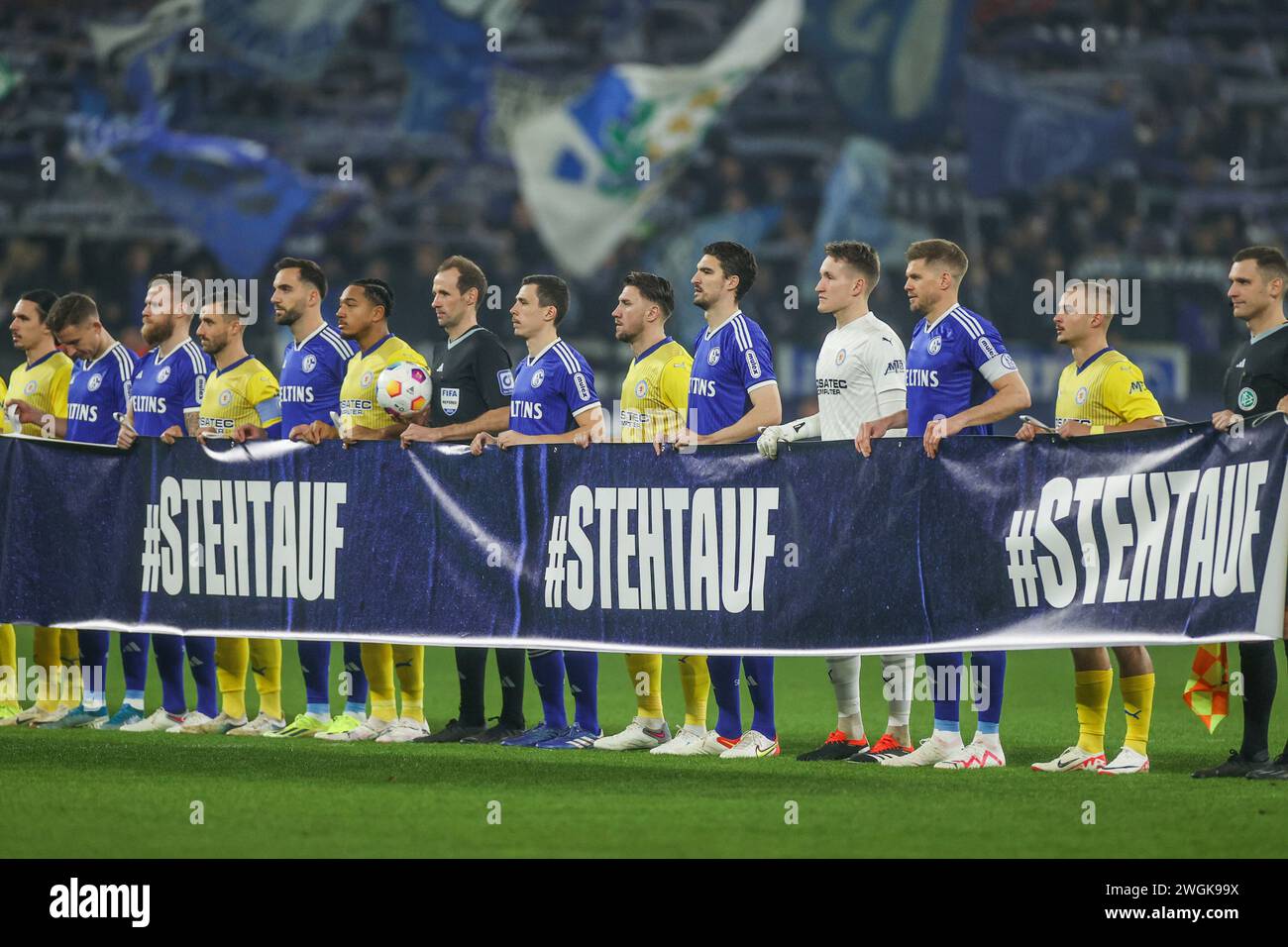 Gelsenkirchen, Deutschland. Februar 2024. 03.02.2024, Fußball, 2. Bundesliga 18. Spieltag, Saison 2023/2024, FC Schalke 04 - Eintracht Braunschweig, Beide Mannschaften halten ein Spruchband für die Aktion #Stehtauf Foto: Tim Rehbein/RHR-FOTO/dpa/Alamy Live News Stockfoto