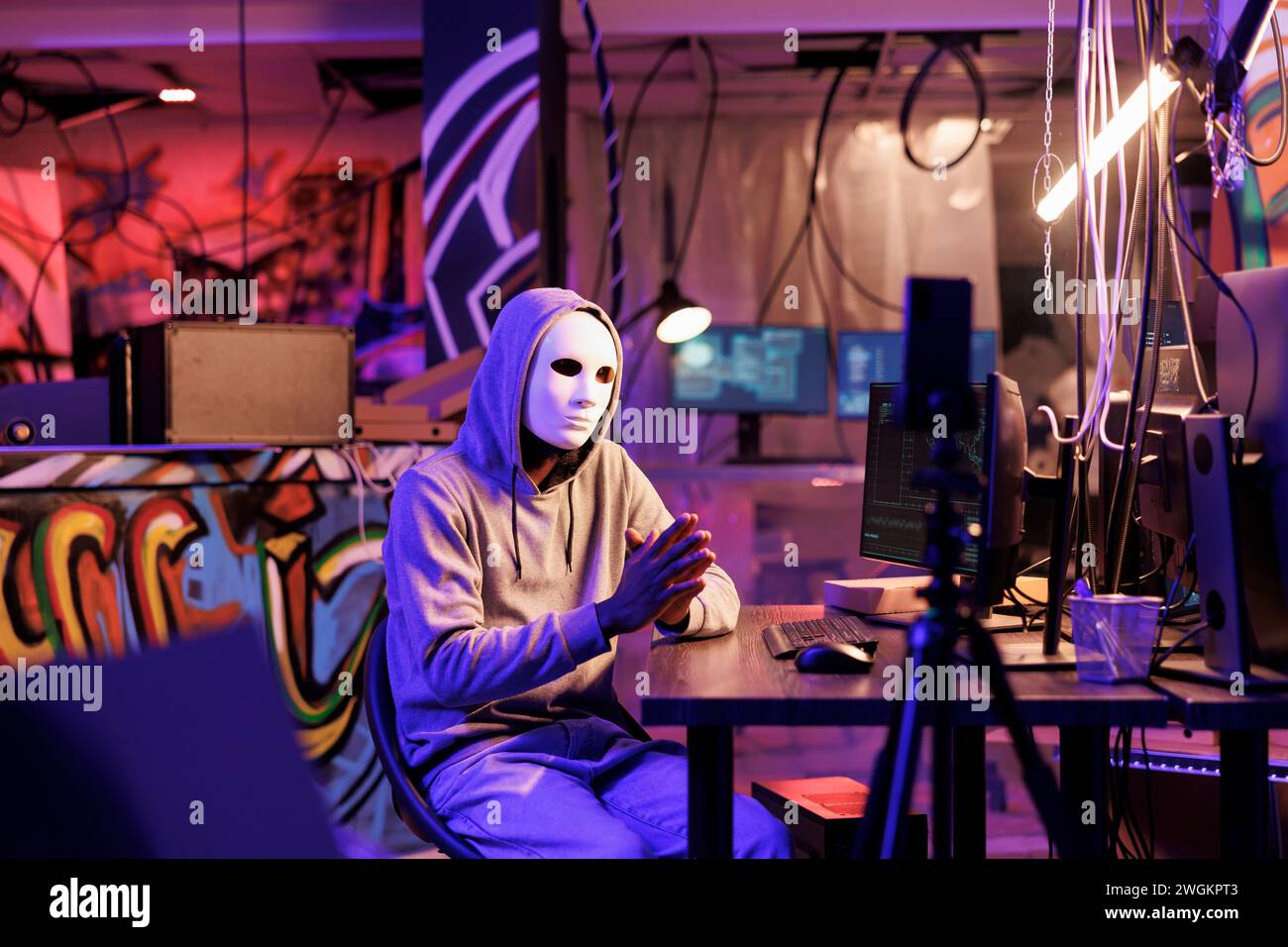 Kriminelle in anonymer Maske, die Online-Betrugsvideo auf Smartphone aufnimmt. Hacker mit versteckter Identität Live-Streaming-Bedrohung auf dem Mobiltelefon und fordern das Opfer nach Informationen im dunklen Web Stockfoto