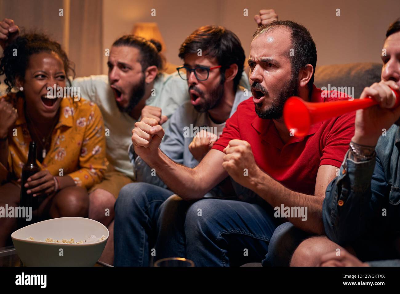 Gruppe von Fans, die schreien und das Ziel des Lieblingsteams mit Freunden am Abend zu Hause feiern Stockfoto