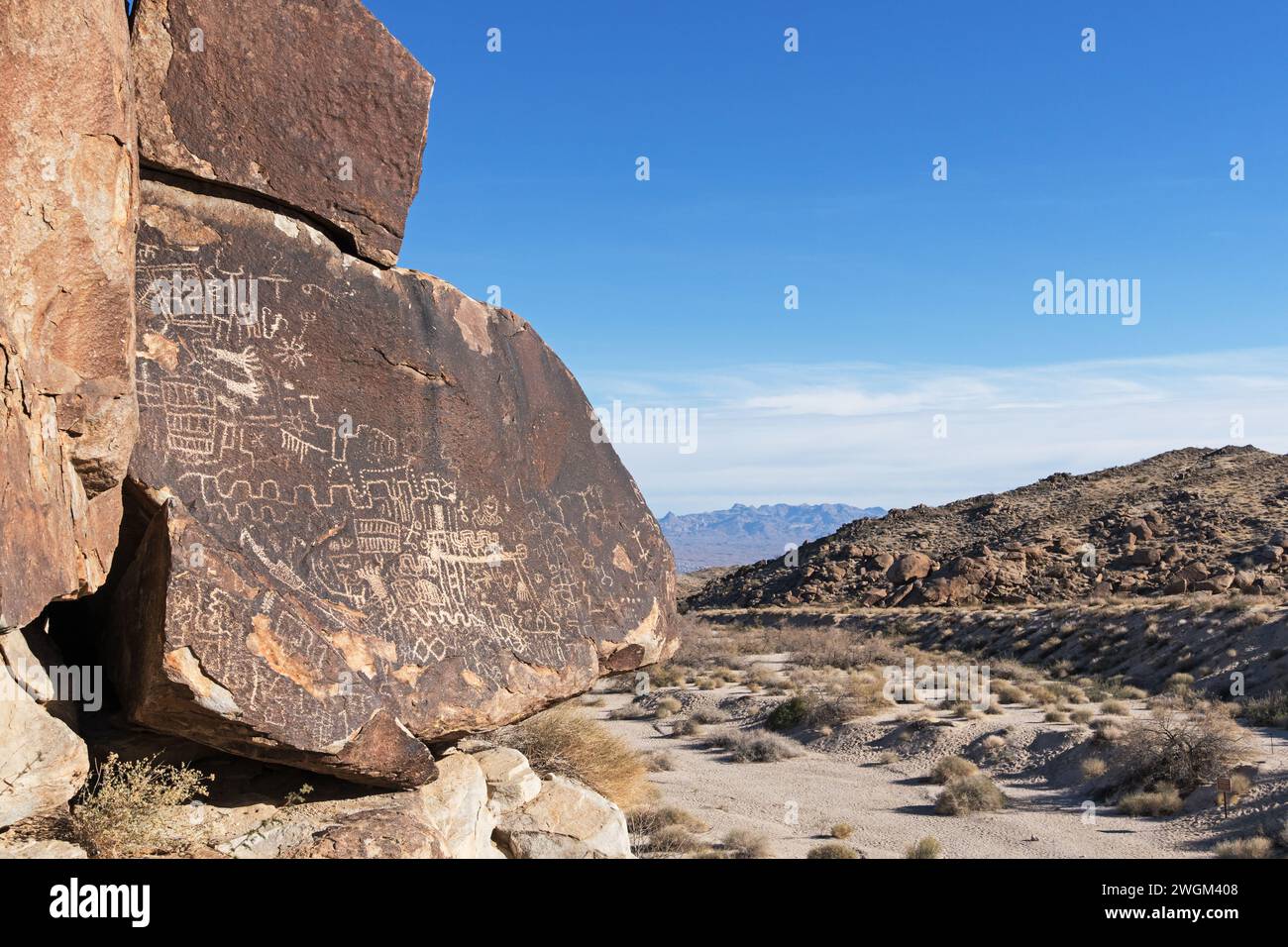 Petroglyphen auf einem Felsbrocken mit Blick auf den Grapevine Canyon im AVI Kwa AME National Monument im Süden Nevadas Stockfoto