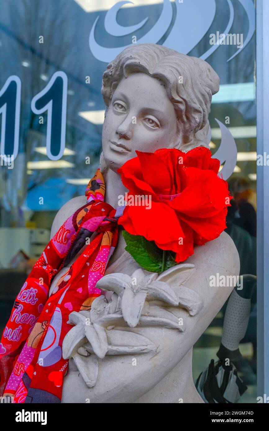 Schaufenster, klassische weibliche Figur mit roter Blumendekoration. Und Schal Stockfoto