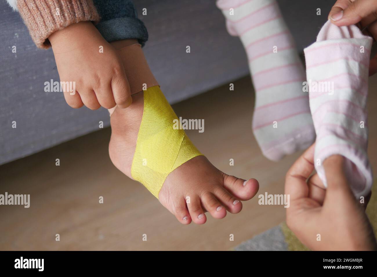 Elastisches therapeutisches Gelbband am Kindesbein. Stockfoto