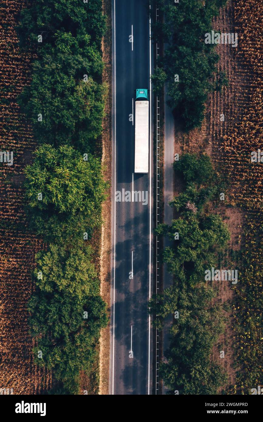 Logistikkonzept für LKW und Gütertransport, Luftaufnahme eines Sattelschleppers auf der Autobahn von Drohne pov, direkt darüber Stockfoto