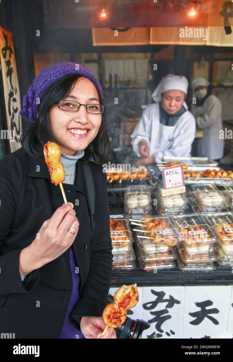 Eine asiatische Frau isst frisch zubereitetes Takoyaki in Gion, Kyoto, Japan Stockfoto