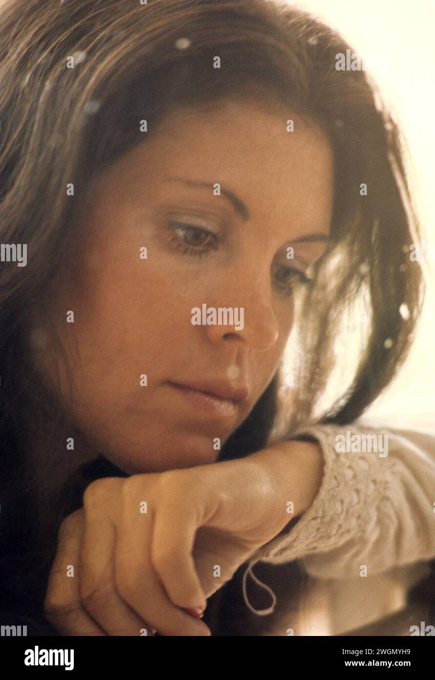 Ziemlich dunkles Haar, junge Frau Porträt, die vor dem Fenster schaut traurige Gedanken Stress; Meditation, träumend gut aussehend Stockfoto