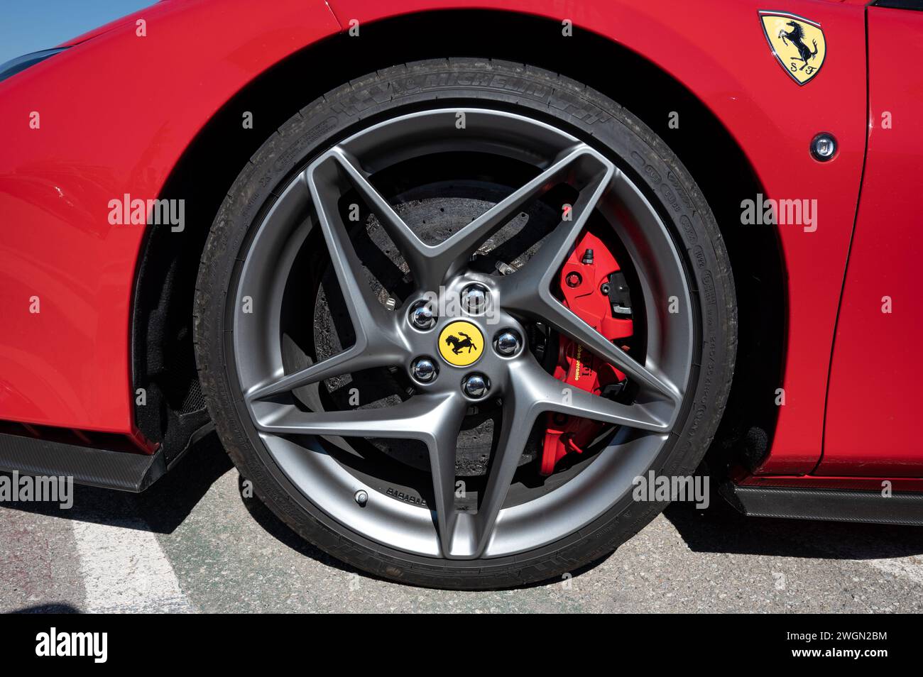 Rad des italienischen Ferrari F8 Tributo Sportwagens. Leichtmetallfelge mit flachem Reifen und großem Bremssattel, der auf eine Carbon-Keramik-Scheibe beißt Stockfoto