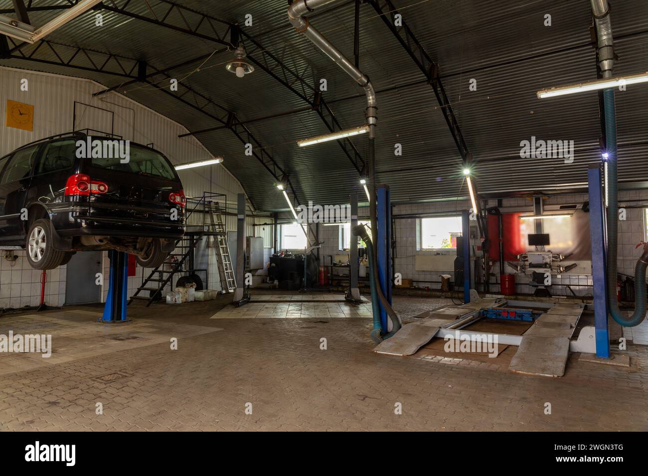 Auto im Kfz-Reparaturzentrum. Autoreparaturstation mit einer großen Anzahl von Aufzügen und spezieller Ausrüstung für Diagnose und Servicereparatur Stockfoto