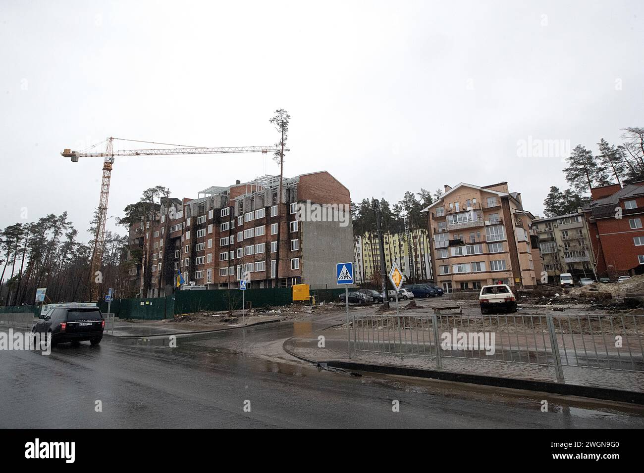 IRPIN, UKRAINE - 05. FEBRUAR 2024 - ein durch russischen Beschuss beschädigter Wohnblock auf dem Gelände des Wohnkomplexes Irpin Lypky in der Hostomelske Shose Straße, wo die Umbauarbeiten laufen, wurde von Teilnehmern der Regionalkonferenz „Wiederaufbau von Wohngebäuden und Bereitstellung von Wohnungen für Binnenvertriebene: Probleme und Lösungen", Irpin, Region Kiew, Nord-Zentral-Ukraine. Stockfoto