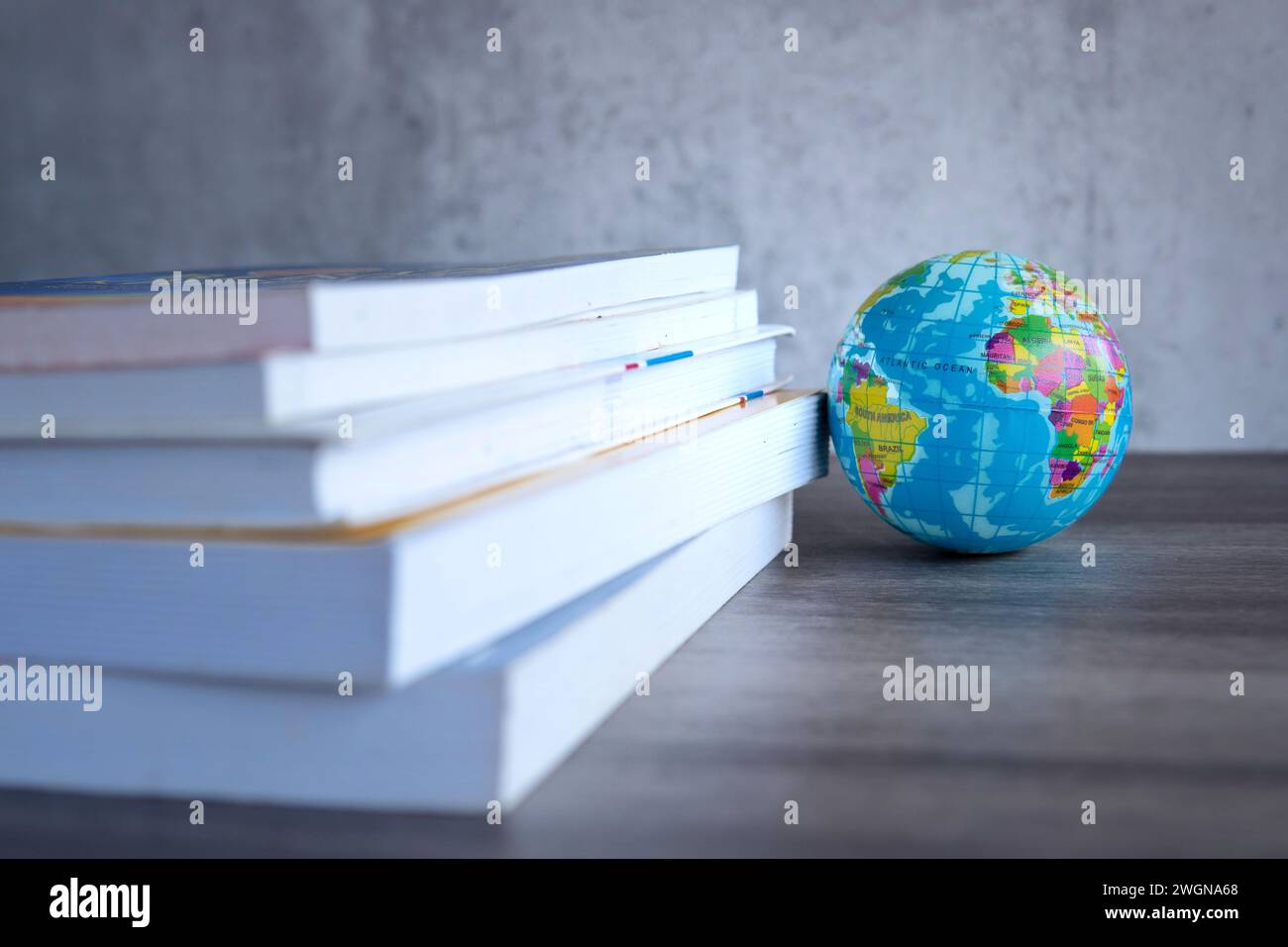Großbildstapel mit Büchern mit einer Kugel auf einem Holztisch. Kopierbereich für Text. Weltbuchtag, Bildung und Wissenskonzept. Stockfoto