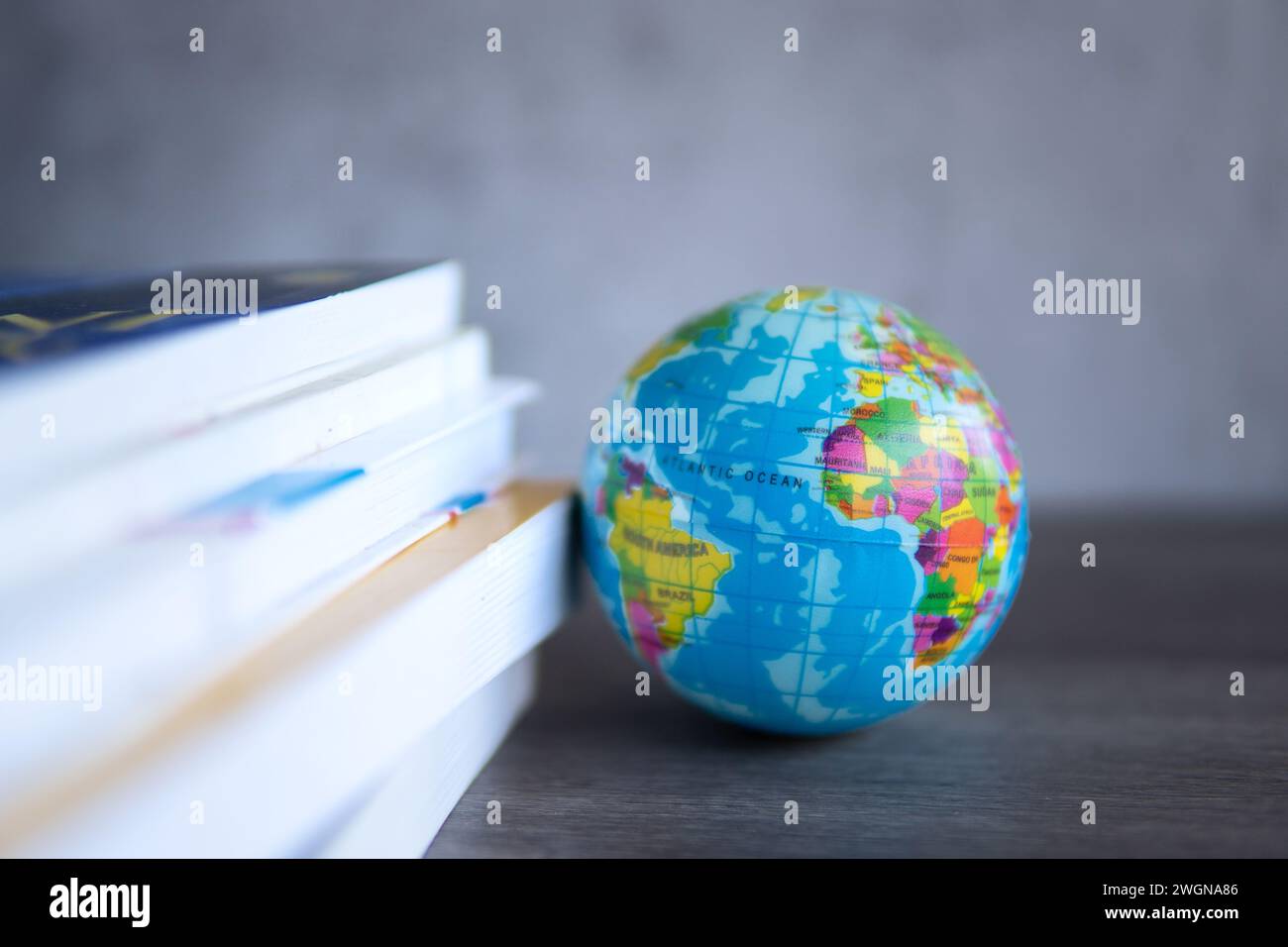 Großbildstapel mit Büchern mit einer Kugel auf einem Holztisch. Kopierbereich für Text. Weltbuchtag, Bildung und Wissenskonzept. Stockfoto