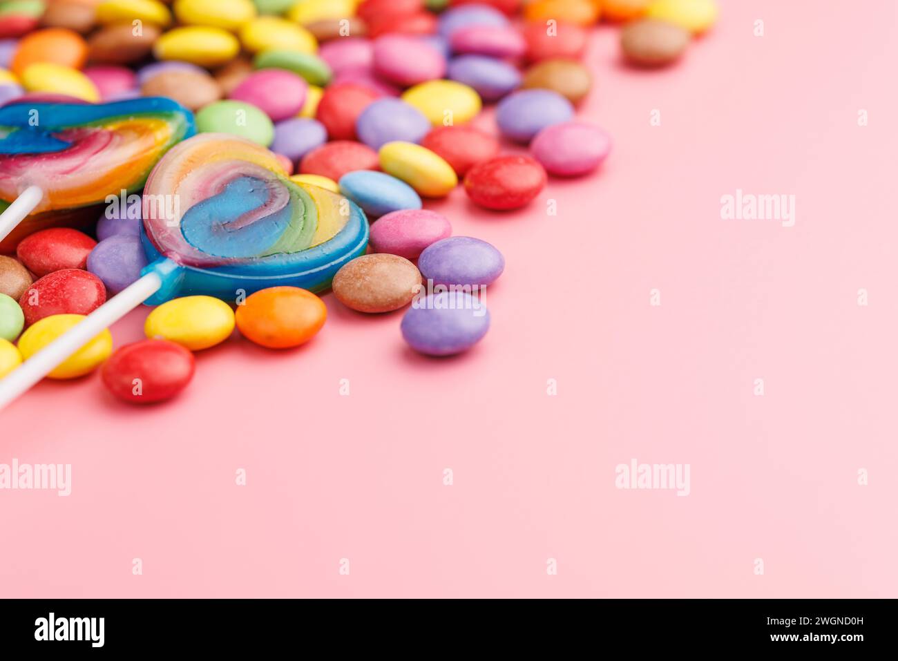 Bunte süße Bonbons und Lutscher. Süße Süßigkeiten auf rosa Hintergrund. Stockfoto