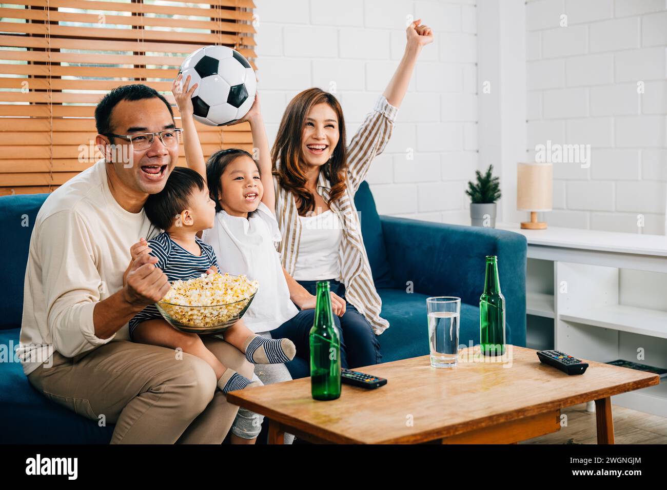 Eine glückliche Familie genießt den Nervenkitzel eines Fußballspiels zu Hause Stockfoto