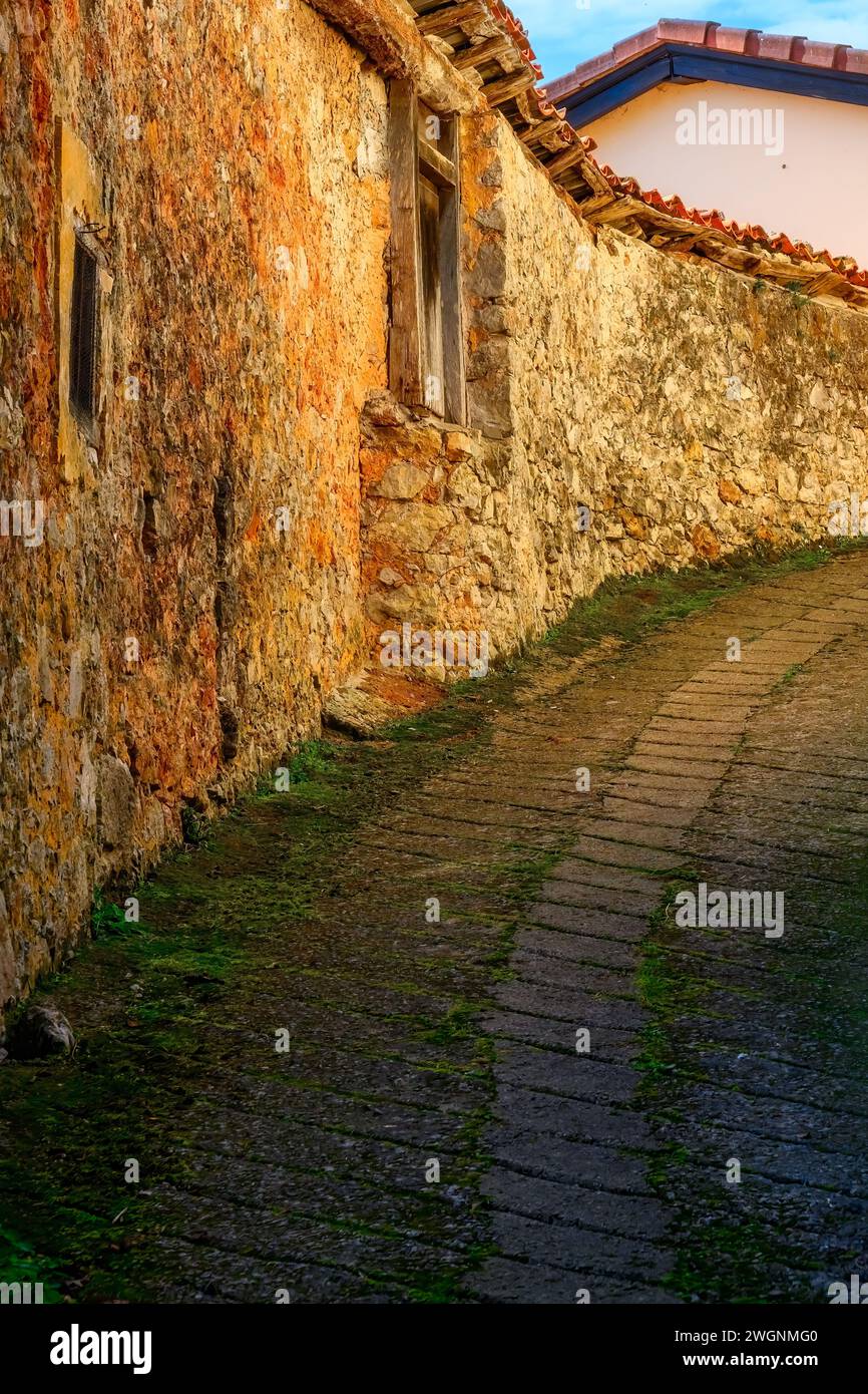 Enge Kopfsteinpflasterstraßen und Steinmauer im Außenbereich des Gebäudes, Cofino, Asturien, Spanien Stockfoto