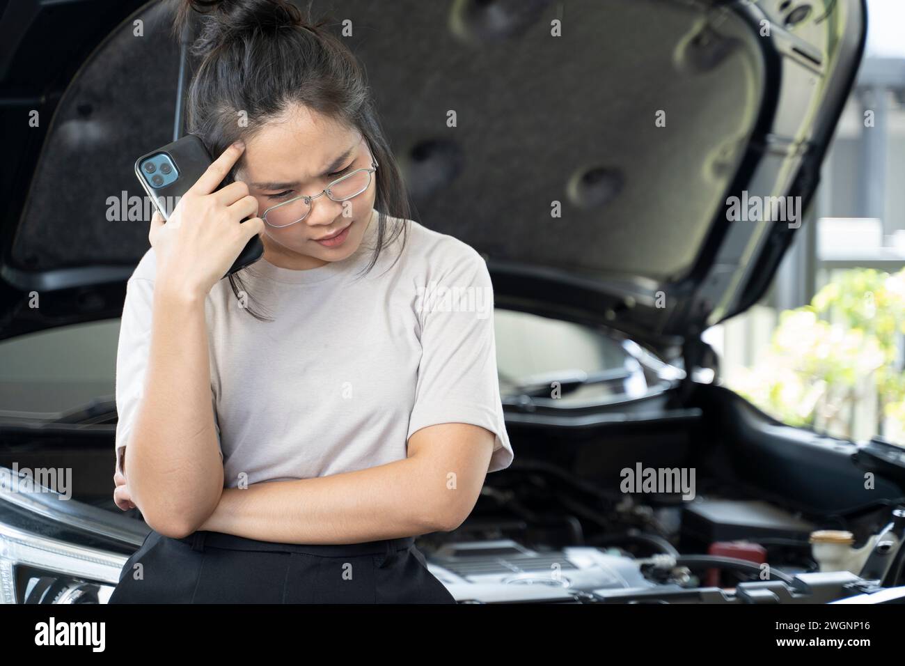 Eine Frau mit Autoproblemen ruft an, um einen Experten zu konsultieren. Stockfoto