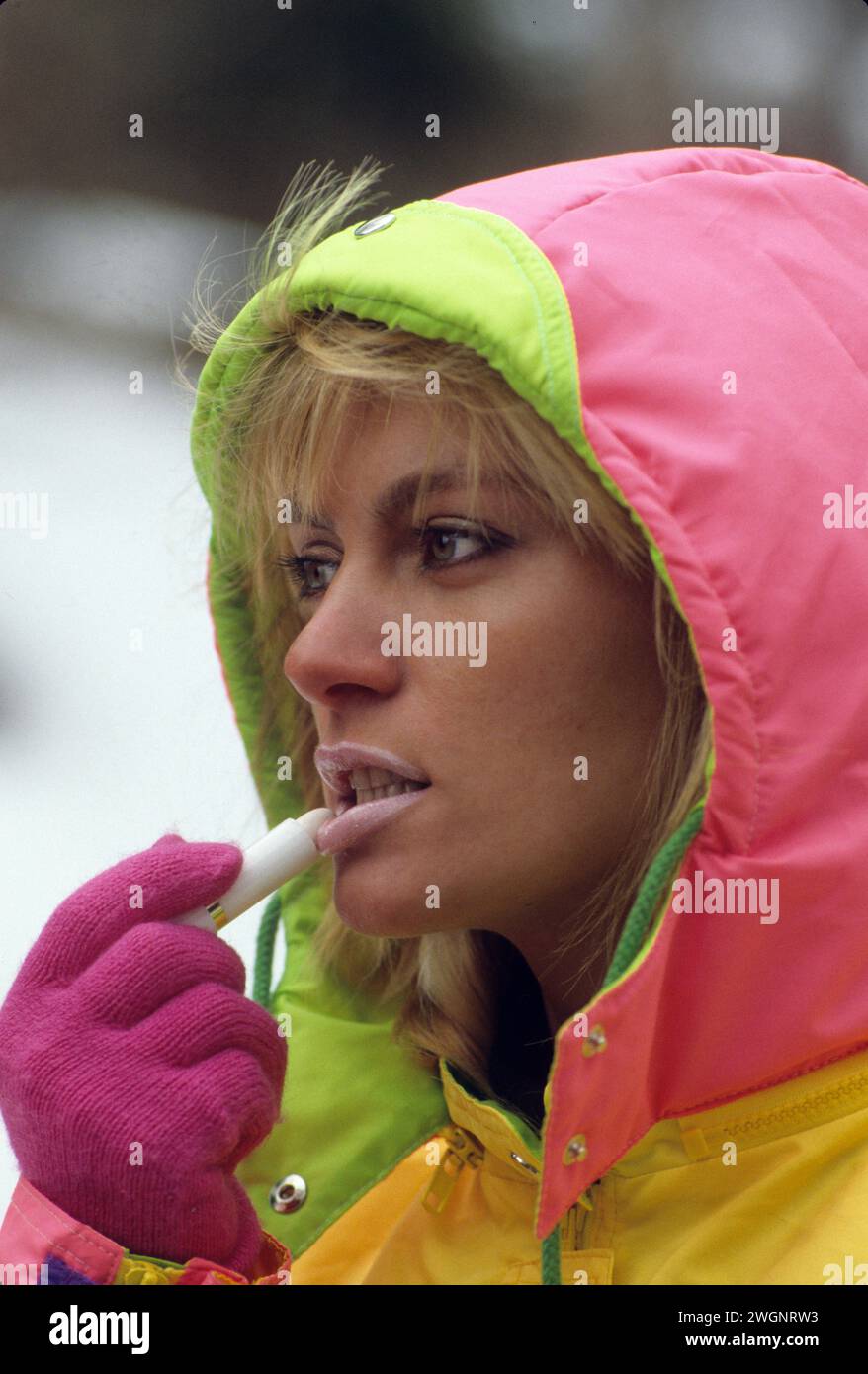 Hübsche blonde Haare junge Frau Porträt Winterzeit Ski Resort Putting kalte Lippencreme sehr süß attraktives Gesicht Stockfoto