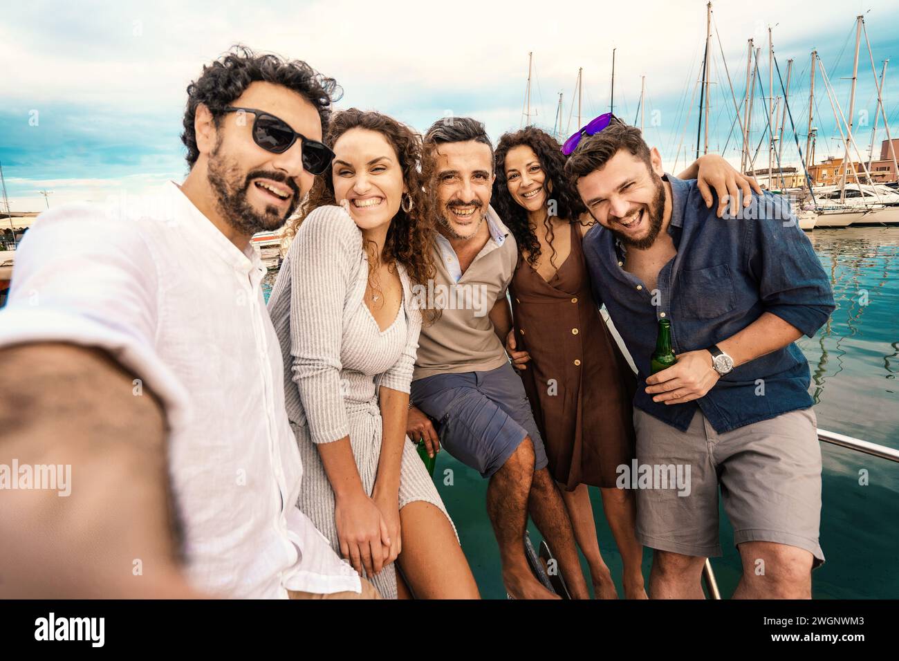 Überschwängliche Gruppe von Freunden, die einen Selfie-Moment auf einer Yacht festhalten und Glück ausstrahlen. Stockfoto
