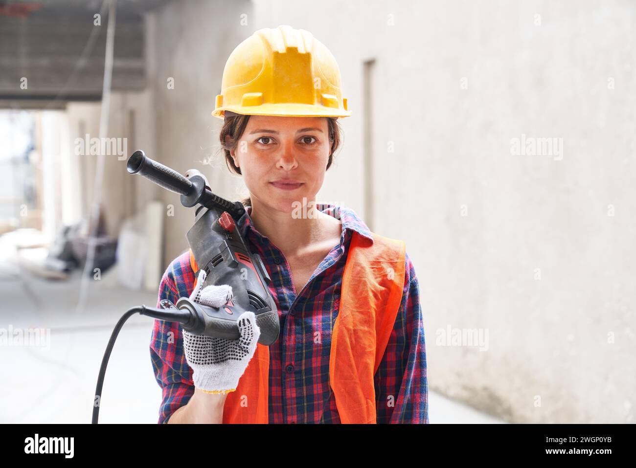 Selbstbewusste Bauarbeiterin, die Arbeitskleidung trägt Stockfoto