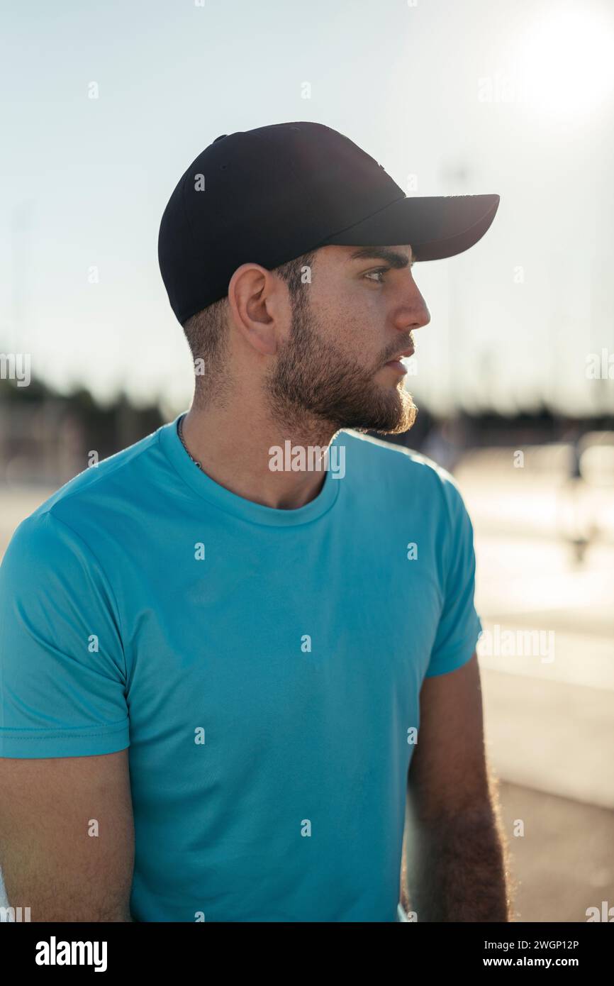 Ein Mann mit Hut, der einen Sportplatz beobachtet Stockfoto