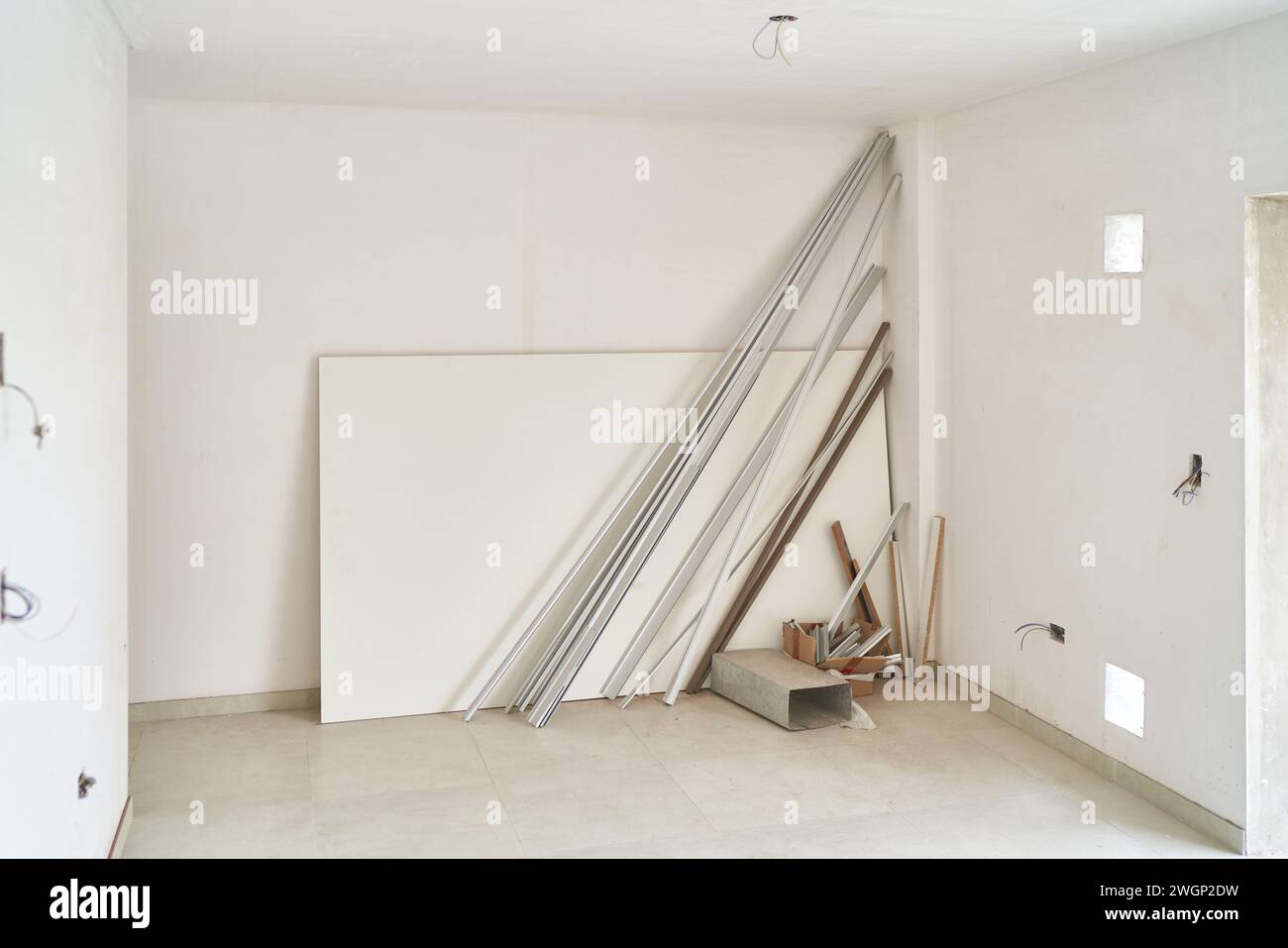 Holzmaterial, das sich an der weißen Wand im Zimmer stützt Stockfoto