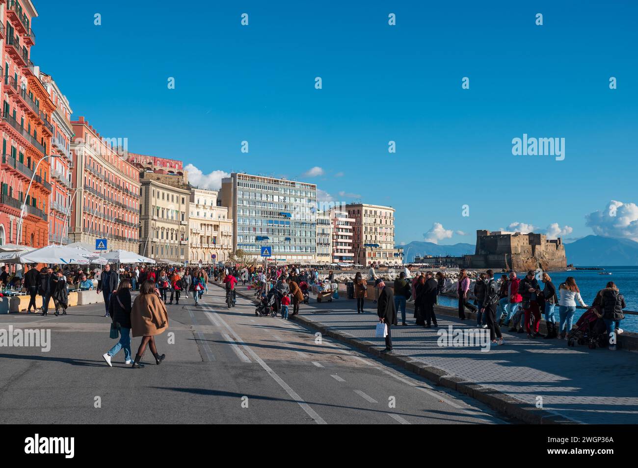 Neapel, Italien - 18. Dezember 2022: Eine geschäftige Menschenmenge von Touristen und Einwohnern, die in stilvoller Outdoor-Kleidung gekleidet sind, erwacht beim caracciolo-Promen Stockfoto