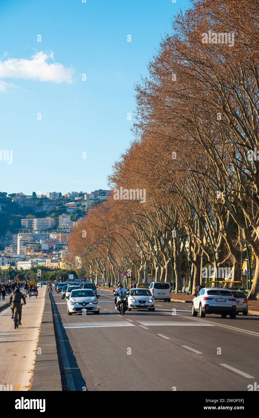 Neapel, Italien - 18. Dezember 2022: Eine belebte Straße in Neapel, Italien, voller lebendiger Menschen und Autos, die entlang des malerischen Caracciolo fahren Stockfoto