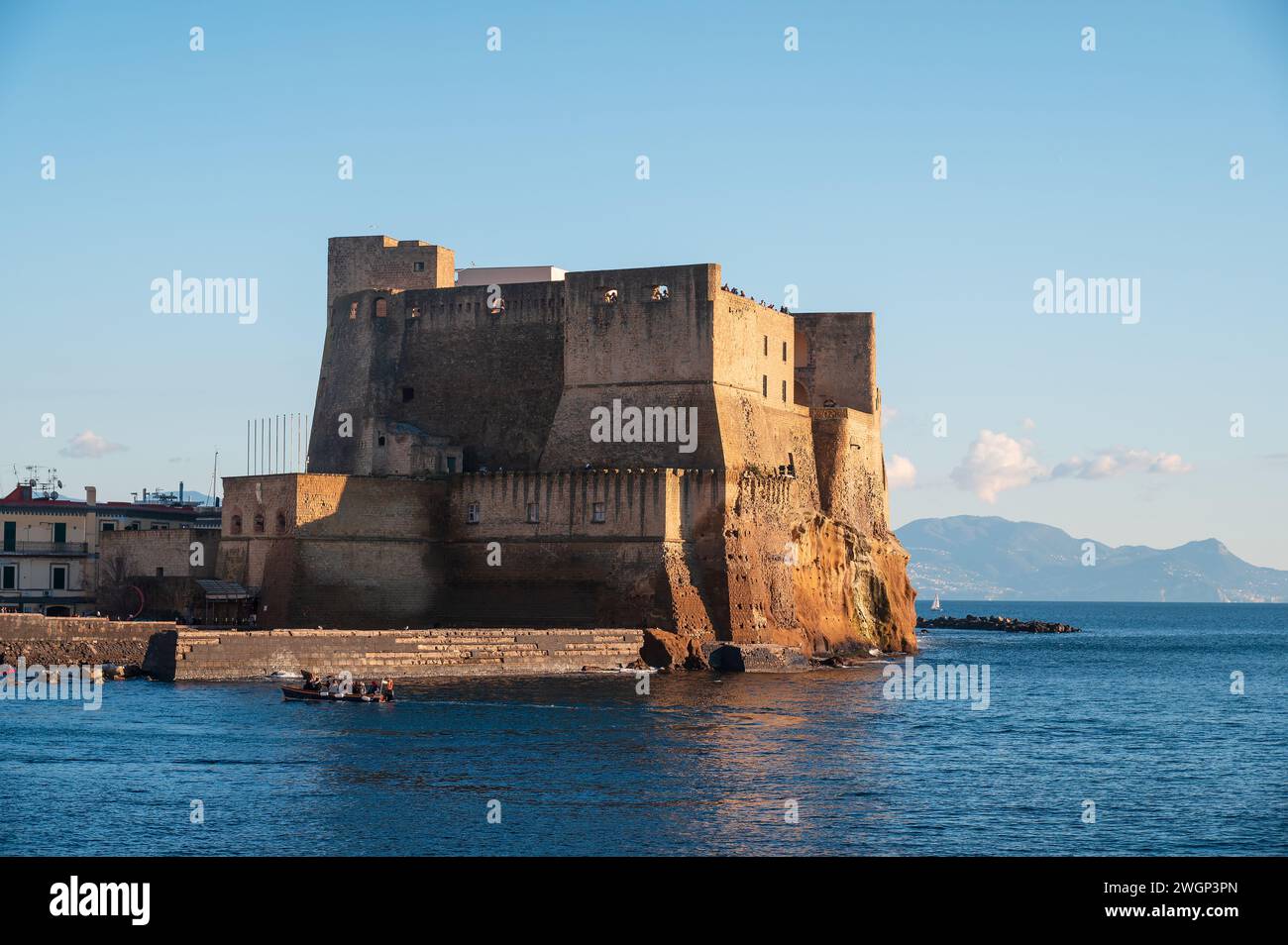 Neapel, Italien - 18. Dezember 2022: Auf einer felsigen Insel steht ein majestätischer Stein aus der Burg Ovo mit Blick auf den ruhigen Golf von neapel. Ikonisches Castel Stockfoto