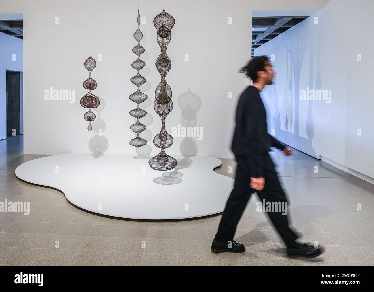 London, Großbritannien. Februar 2024. A Visitor with Ruth Asawa, Untitled, Hanging Lobe Works, c.1958. „When Forms Come Alive – Sixty Years of Restless Sculpture“ ist eine spielerische und lebendige Ausstellung, die zeigt, wie Künstler von Bewegung, Flux und organischem Wachstum inspiriert wurden. „When Forms Come Alive – Sixty Years of Restless Sculpture“ ist eine spielerische und lebendige Ausstellung, die zeigt, wie Künstler von Bewegung, Flux und organischem Wachstum inspiriert wurden. Quelle: Imageplotter/Alamy Live News Stockfoto