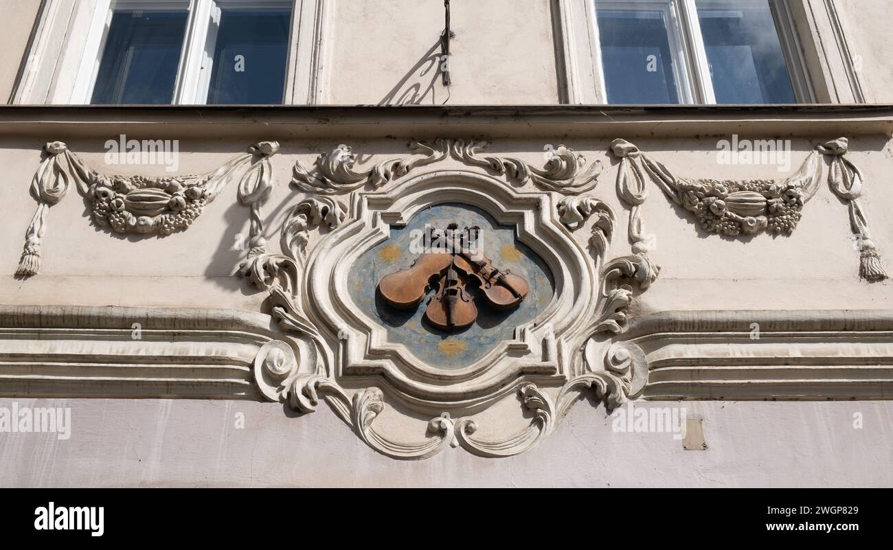 Ein Hausschild mit drei Violinen in der Nerudova-Straße 12 (heute The Three Fiddles Irish Pub), Malá Strana, Prag, Tschechien. Stockfoto