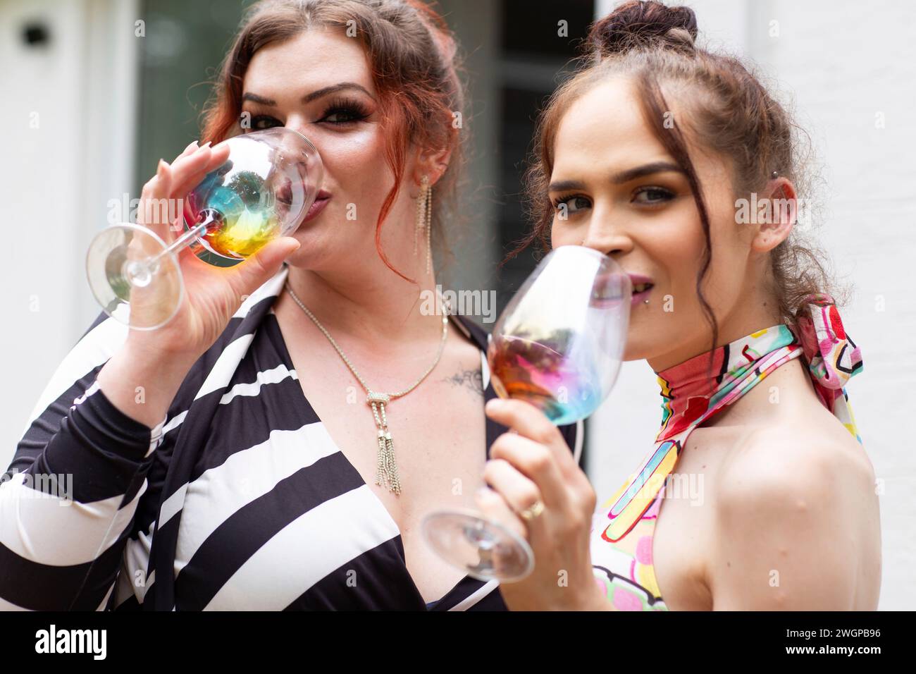 Porträt von zwei Transfrauen, die Wein auf einer Sommergartenparty trinken Stockfoto