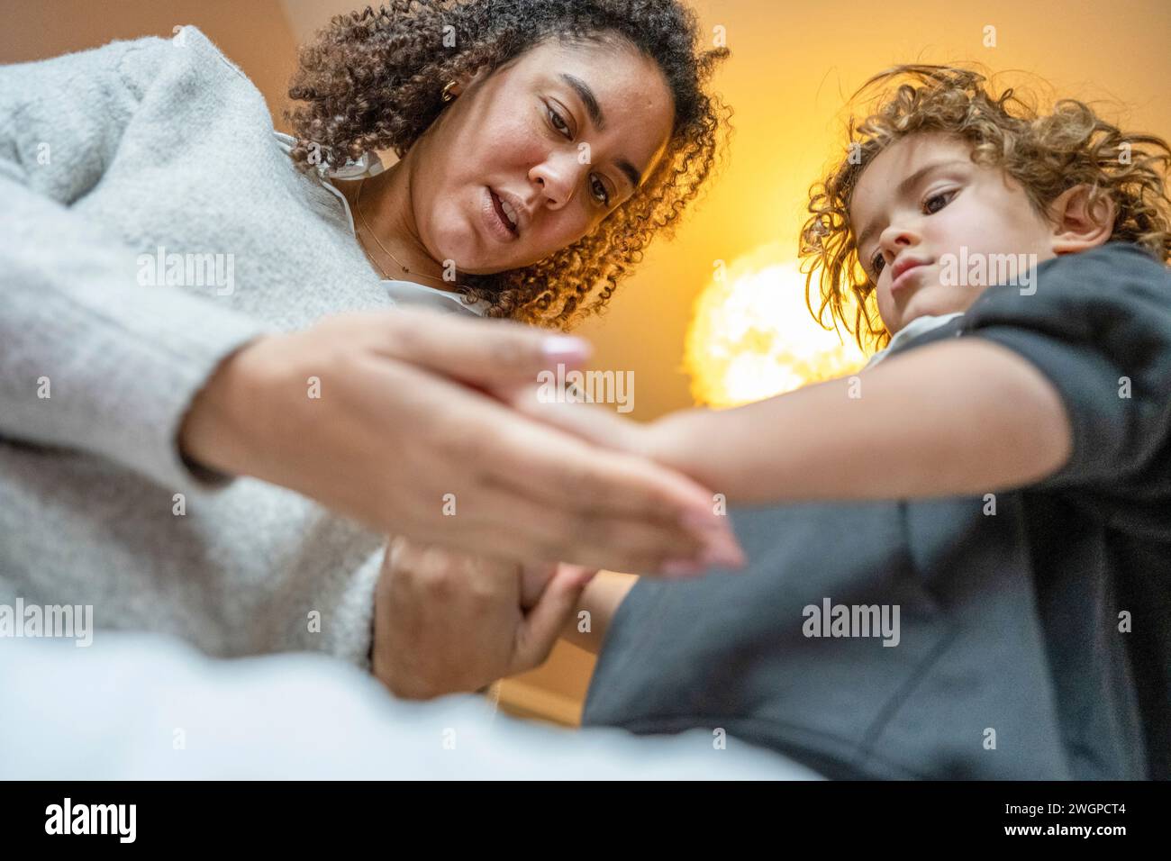 Mutter und Sohn schauen sich ihre Hände an und verbrachten Zeit miteinander Stockfoto