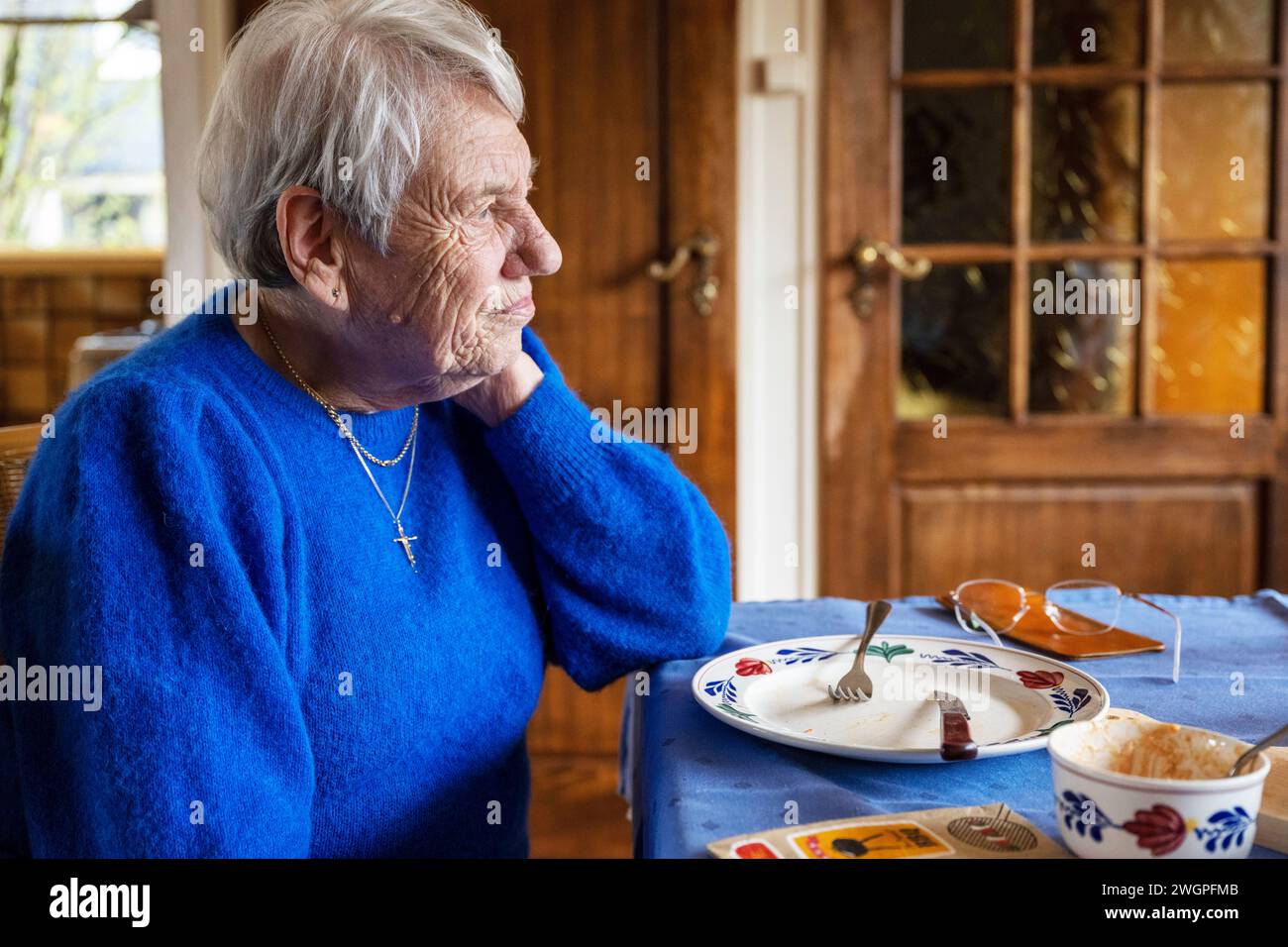 Elderley Lady sitzt beim Frühstück und denkt über das Leben nach Stockfoto