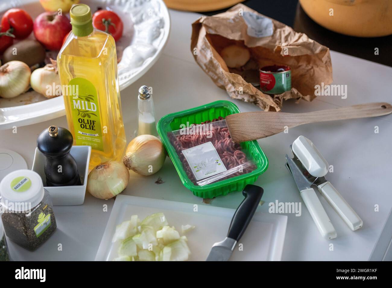 Erwachsener Mann, der Hackfleisch für eine Lasagne in seiner modernen Küche zubereitet Stockfoto
