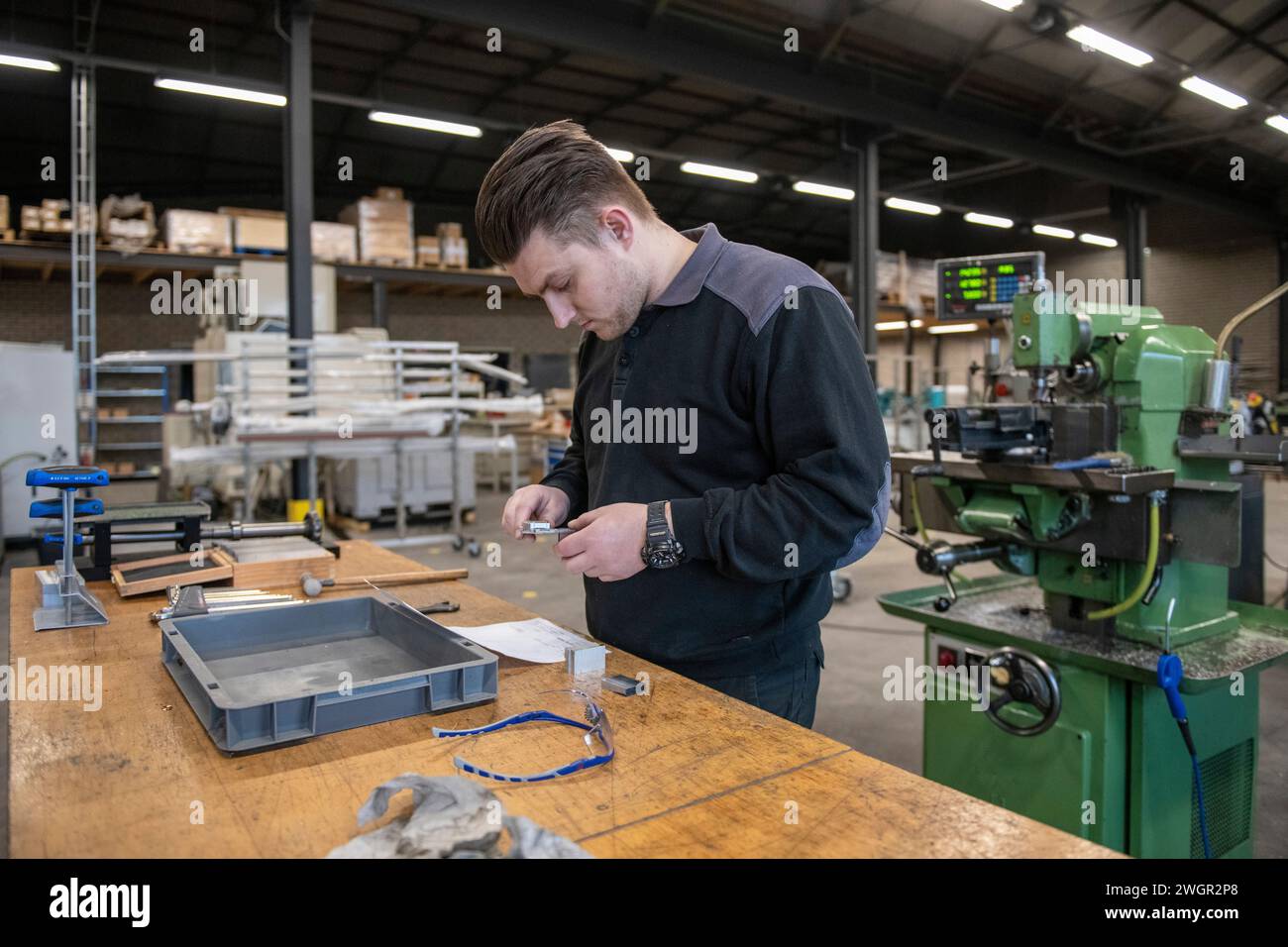 Junger Maschinenbauingenieur, der in einer Fabrik an Stahlmaschinen arbeitet Stockfoto