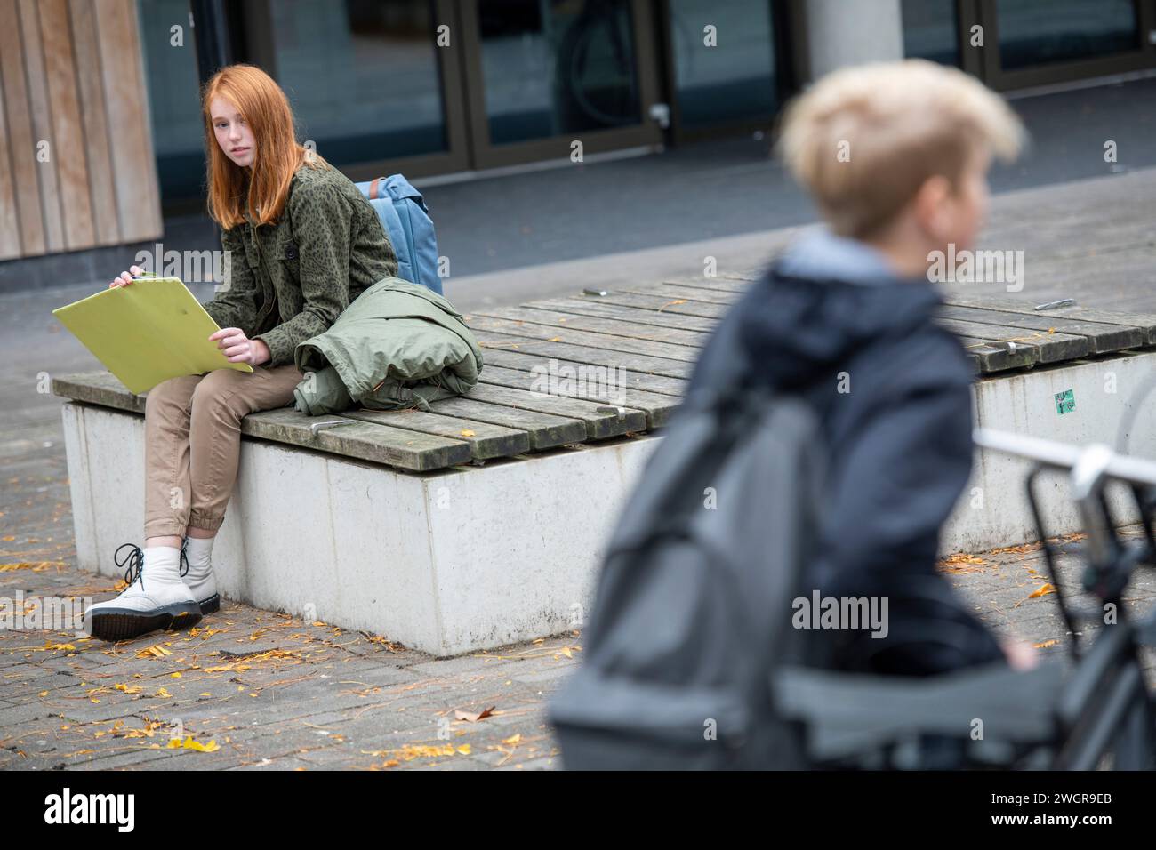 Teenager-Mädchen sitzen auf dem Spielplatz und lernen Stockfoto