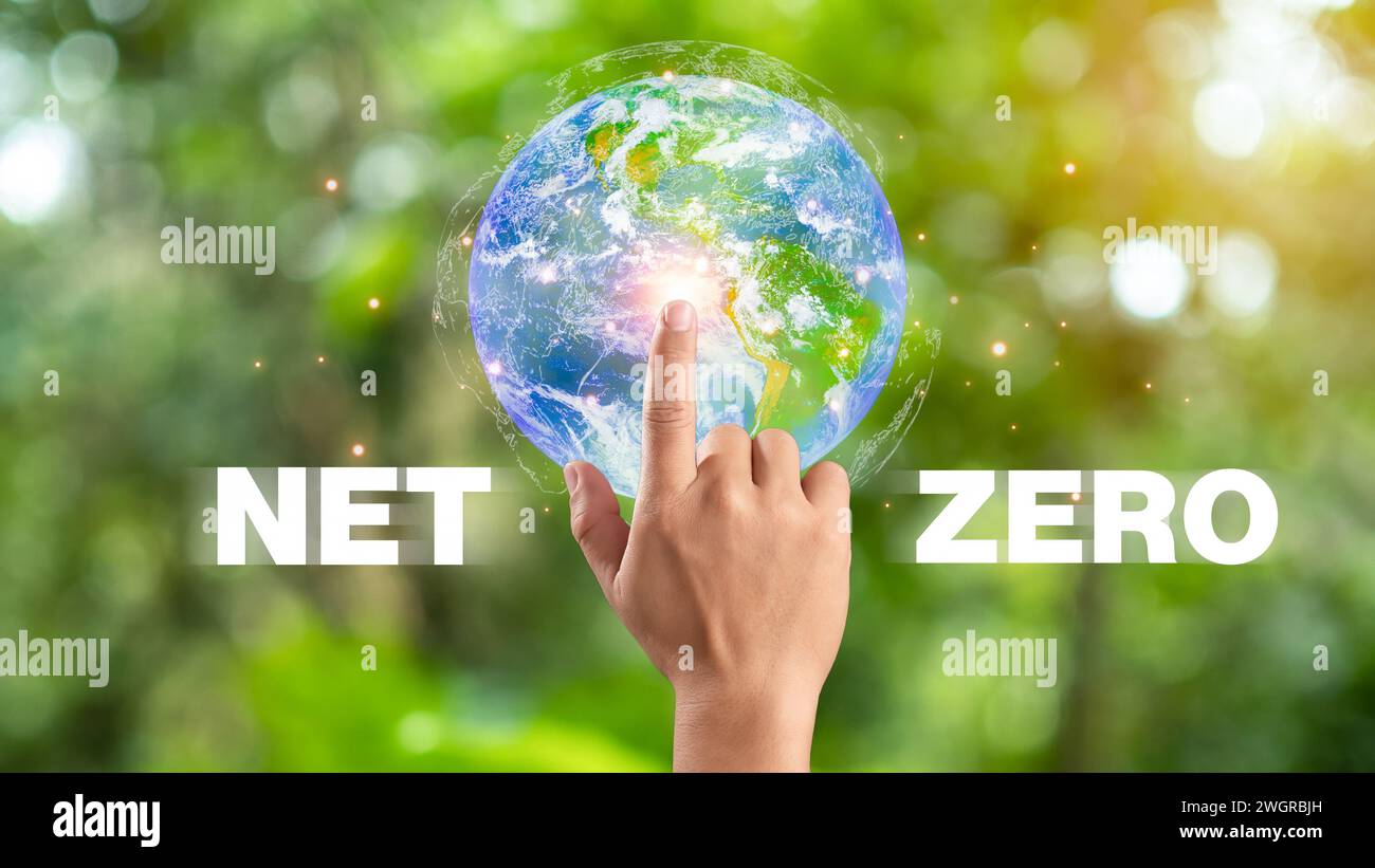 Hand des Menschen, die auf das Symbol Erde und Netz Null zeigt, CO2-neutral und Netz Null Konzept für das Ziel der Nettoemissionen von Treibhausgasen Null, klimaneutral l Stockfoto