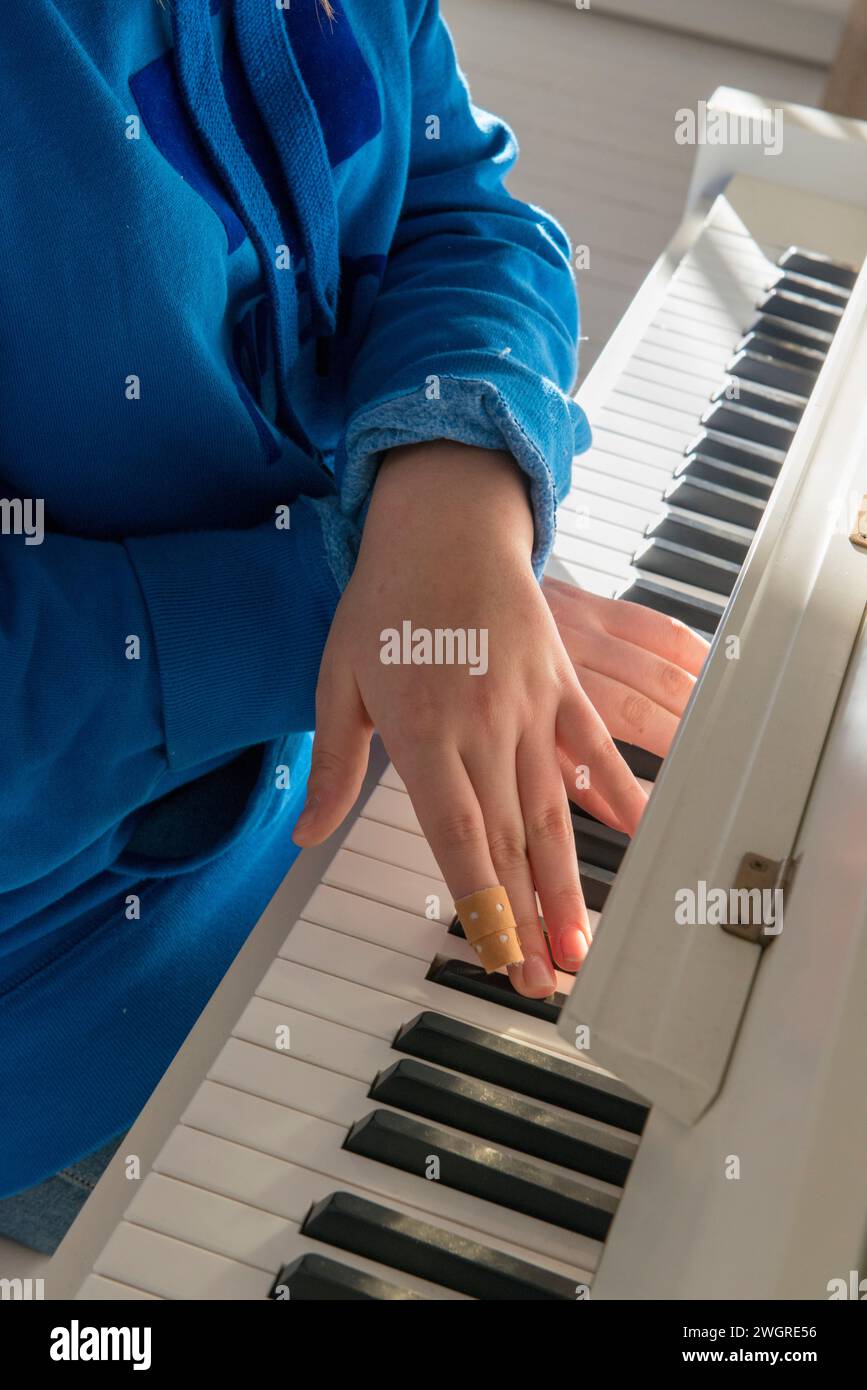 Teenager-Mädchen, das Klavier mit einem Verband übt Stockfoto