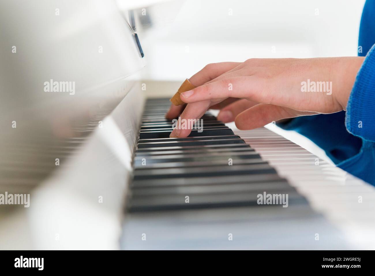 Teenager-Mädchen, das Klavier mit einem Verband übt Stockfoto