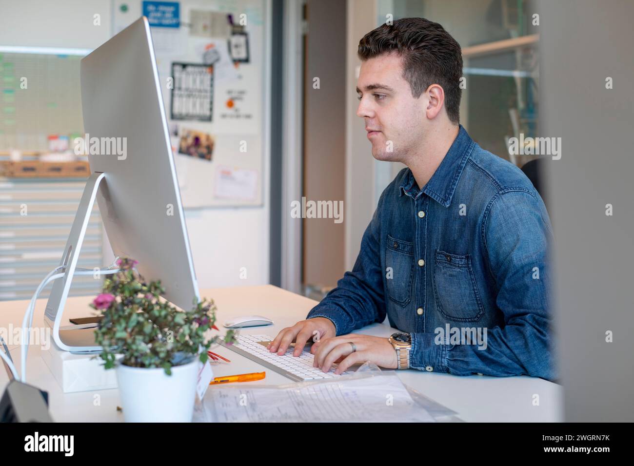 Männlicher junger weißer Profi, der in einem Architektenbüro an einem Neubauprojekt arbeitet Stockfoto