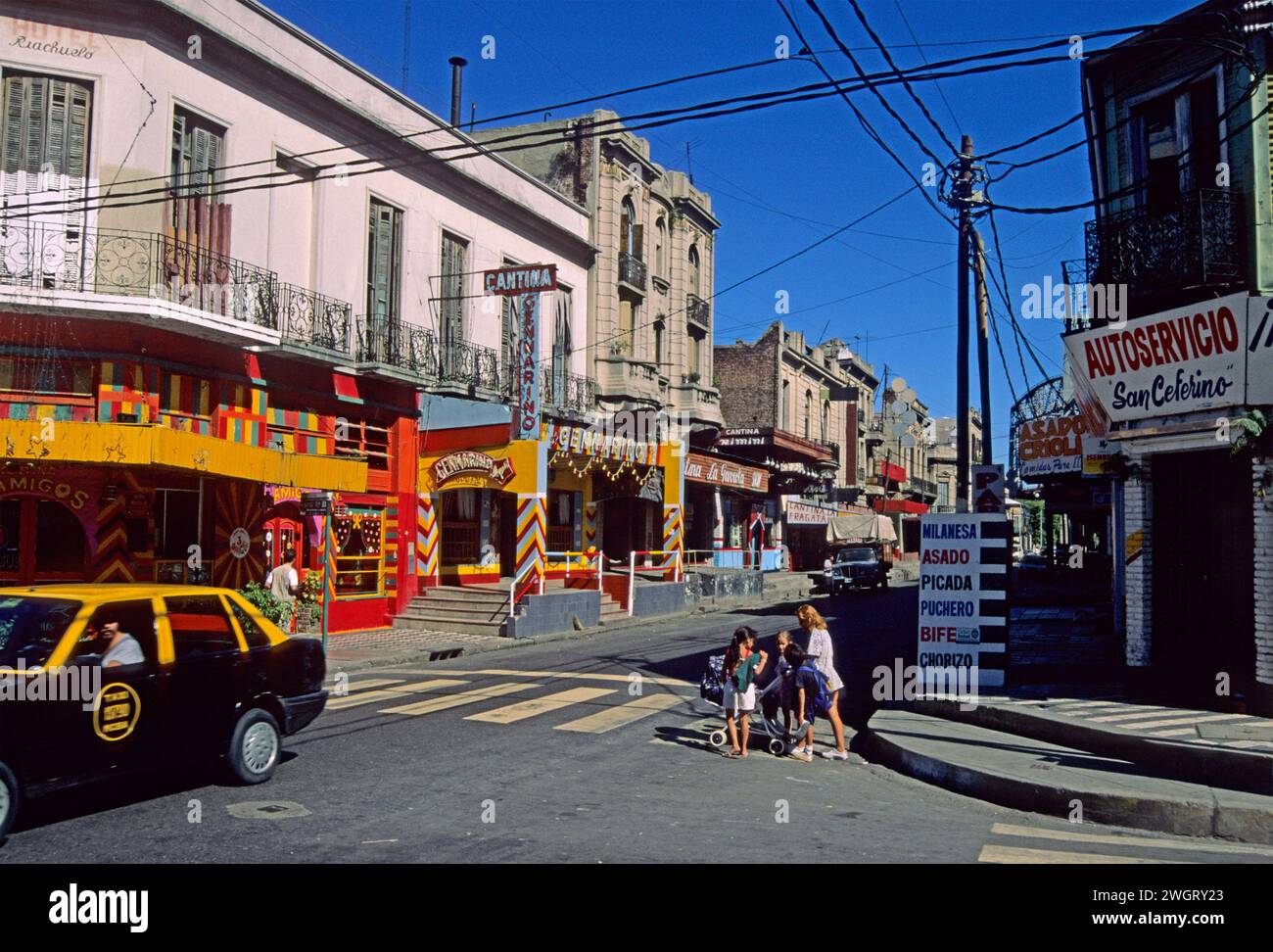 Frau mit Kindern auf einer Fußgängerüberfahrt in der calle Necochea, La Boca Bezirk, Buenos Aires, Argentinien Stockfoto