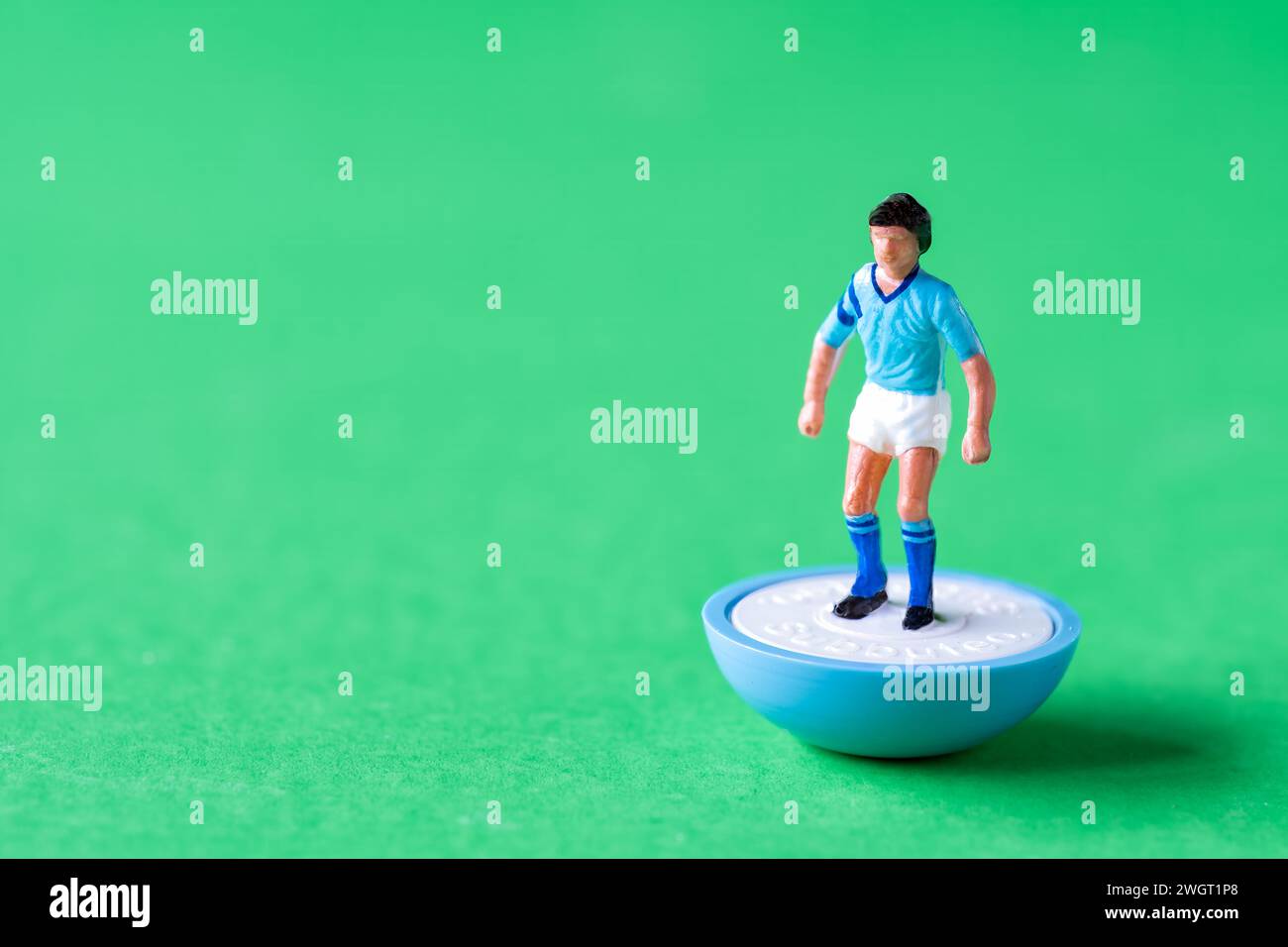Eine einzelne Subbuteo Minifigur in den Farben der Manchester City FC Heimmannschaft mit himmelblauem Shirt, weißen Shorts und himmelblauen Socken. Stockfoto
