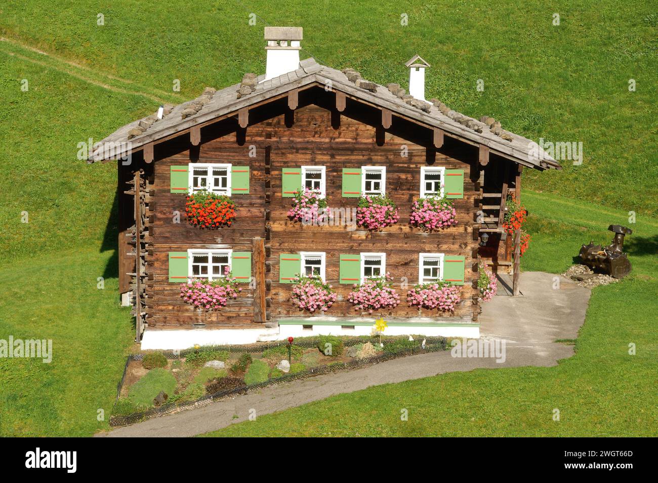 Traditionelles hölzernes Bauernhaus umgeben von Wiesen in der Nähe von Mittelberg, Kleinwalsertal, Vorarlberg, Österreich Stockfoto