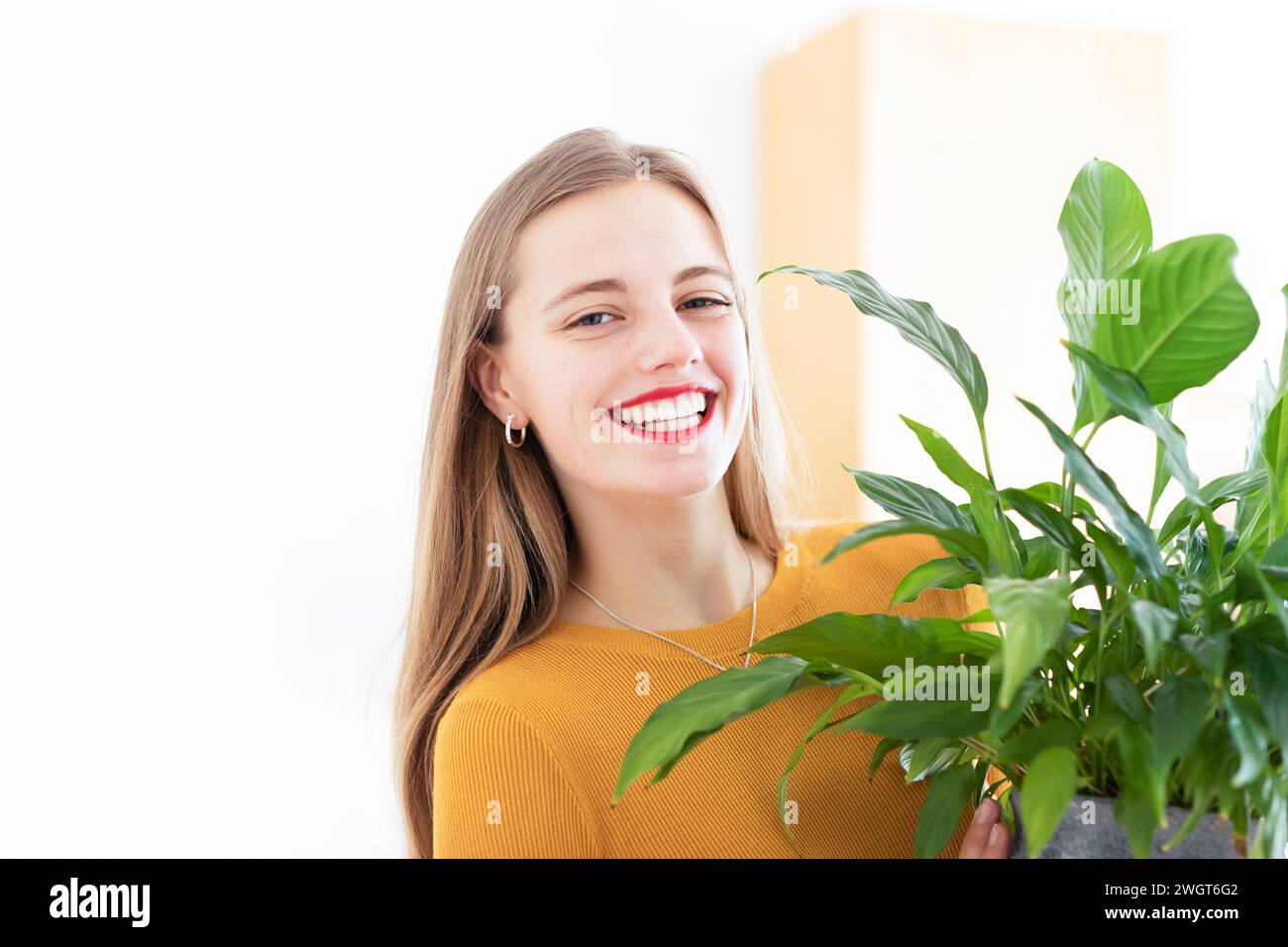 Junge Frau in einem Zimmer mit grünen Pflanzen Stockfoto